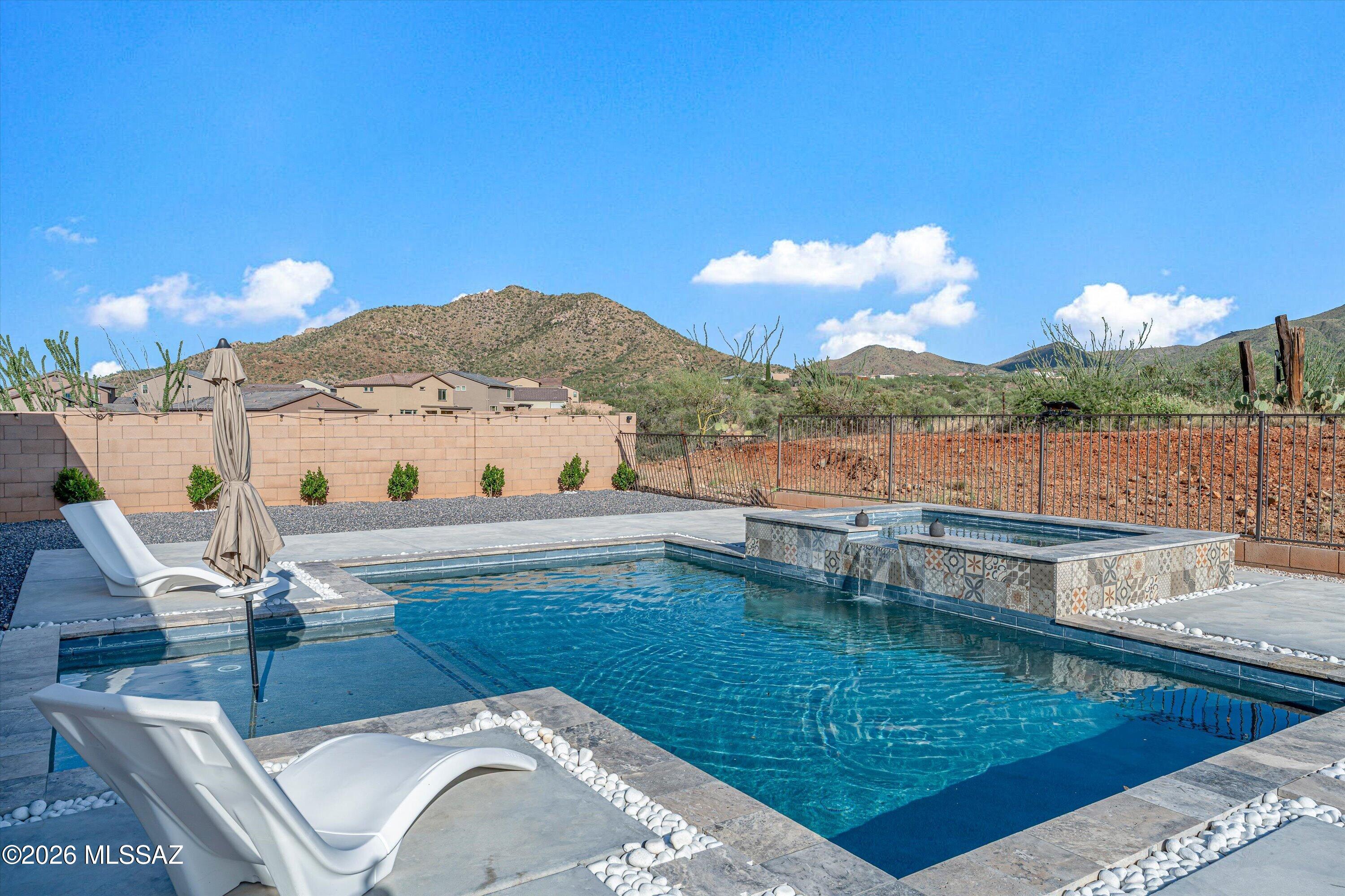 This GORGEOUS home has it all.  Better-than-new Lennar Wayfarer with lovely upgrades, oversized extended patio, pool, spa, water feature. Built-in BBQ, cul-de-sac premium lot, mountain views, paid off solar, huge storage room, and a fully landscaped yard.  This 5-bedroom, 4-bath home has a 4-car garage (1 of the 3 garage doors has tandem parking), plus one bedroom and a 1-bath attached guesthouse/mother-in-law suite with a separate entry. Large kitchen with tons of storage, a waterfall quartz countertop on the island, and an open, airy great room. The owner's suite is on the ground floor with a lovely en-suite and a walk-in closet. Upstairs, there are 3 more bedrooms, a full bathroom, a loft area, and a full-sized laundry room.