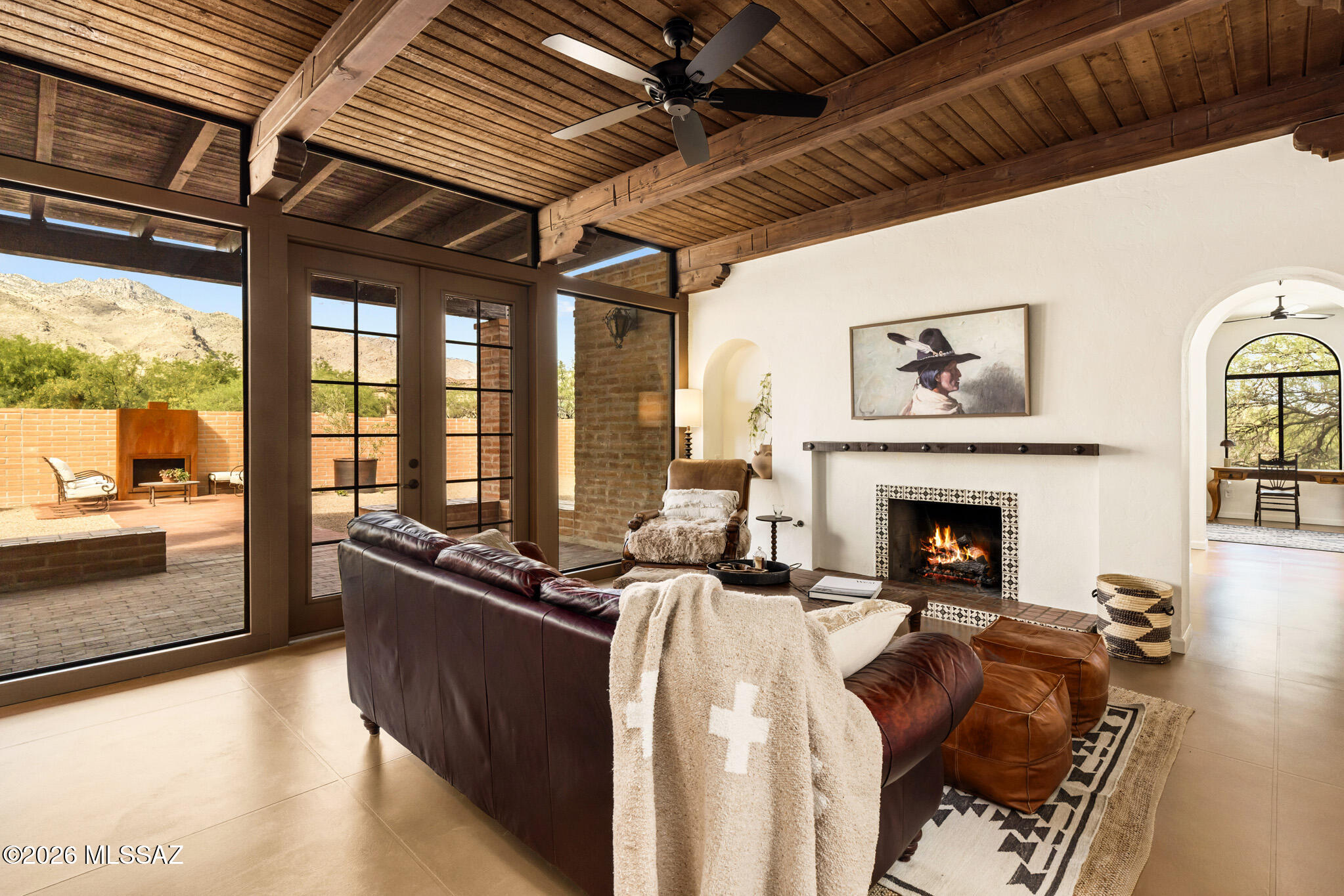 Majestic mountain views await in this hacienda-style burnt adobe home, ideally situated on 1.44 acres on a tranquil cul-de-sac in Indian Trails Estates.  This 4bd/4ba architect-designed home was thoughtfully imagined to accommodate a variety of needs. There is a roomy, attached 3-car garage and an ADDITIONAL attached 5-car garage with 2 new mini-splits- adding 1,216 sq ft of flex space! This classic home has been conscientiously renovated by a designer committed to preserving its original beauty while tastefully updating it for modern living with authentic materials, including new concrete floors, KraftMaid Alder cabinets, quartz countertops, new plumbing fixtures & tile, and a curated mix of new, vintage, and custom lighting. See complete list of amenities and improvements. Owner/agent. Enter through a spacious enclosed courtyard, ideal for additional entertaining space, and step through the double wooden doors into a generous foyer flanked by the formal dining room and living room. These three spaces all feature handsome original wood French doors that open to the courtyard, with optional screens that can be reinstalled to welcome fresh desert air nearly year-round.

Beyond, the family room connects seamlessly to the kitchen, keeping everyone together while showcasing a wall of dual-paned low-E windows and French doors that frame magnificent mountain views. A Mexican tile-trimmed gas fireplace adds warmth and character and is pre-wired for media above.

The kitchen is outfitted with new KraftMaid stained alder and painted maple cabinets, including 42-inch uppers and a convenient snack station with built-in microwave. Roomy drawers and pullouts provide exceptional storage, while open shelving keeps décor or frequently used items within easy reach. Durable new concrete-look quartz counters surround the new fluted workstation sink, complete with a cutting board and drop-in strainers. Brand-new GE Café stainless steel appliances with copper accents include a French-door refrigerator, dishwasher, and induction range with dual oven. The breakfast nook is anchored by a striking arched window trimmed with original Mexican hand-painted tile.

The primary suite features abundant closets as you enter through a dressing area flooded with natural light into the private retreat featuring a glorious shower with rainhead and mountain views, soaking tub, and dual vanities. Unwind as a fire dances in the fireplace and your gaze rests onto the looming Catalina mountains beyond. Start your morning on the enclosed primary suite patio with coffee and the aroma of Star Jasmine awakening your senses. The private patio is large enough for an outdoor shower, tub, or cold plunge in addition to lounging and relaxation space.

At the other end of the home, the library hall featuring built-in bookcases with viewing shelves leads you to two additional spacious bedrooms. One is an ensuite with walk-in closet and direct backyard access. The other features its own well-appointed bathroom just outside the doors. The large office with closet could easily function as a fourth bedroom, playroom or media room.

There is a roomy attached 3-car garage, but the most desirable feature of the home might be the attached 5-car garage / workshop with two new mini-splits- offering an additional 1,216 feet of air-conditioned flex space. Even with cars parked in it, there is plenty of room for man-cave, workout space, or teen hangout- the possibilities are endless. Both garage floors have been newly recoated and the 5-car garage features windows with mountain views and French doors that open to the rear of the home near the backyard.

The spacious, low-care, walled backyard features a deep covered porch and brick patio and could easily accommodate a pool along with additional play or entertaining areas.

Located just west of Ventana Canyon, this home is situated in the prestigious Catalina Foothills School District 16 and is just a two-minute drive to Sabino Canyon recreation area. Fine dining, shopping, Moccasin Trail, the Tucson Auto Museum and more are all just minutes away.

Whether you're seeking space for family, visitors, or a home that supports hobbies and retirement living, this property offers exceptional flexibility and comfort with no HOA in a most scenic desert setting.