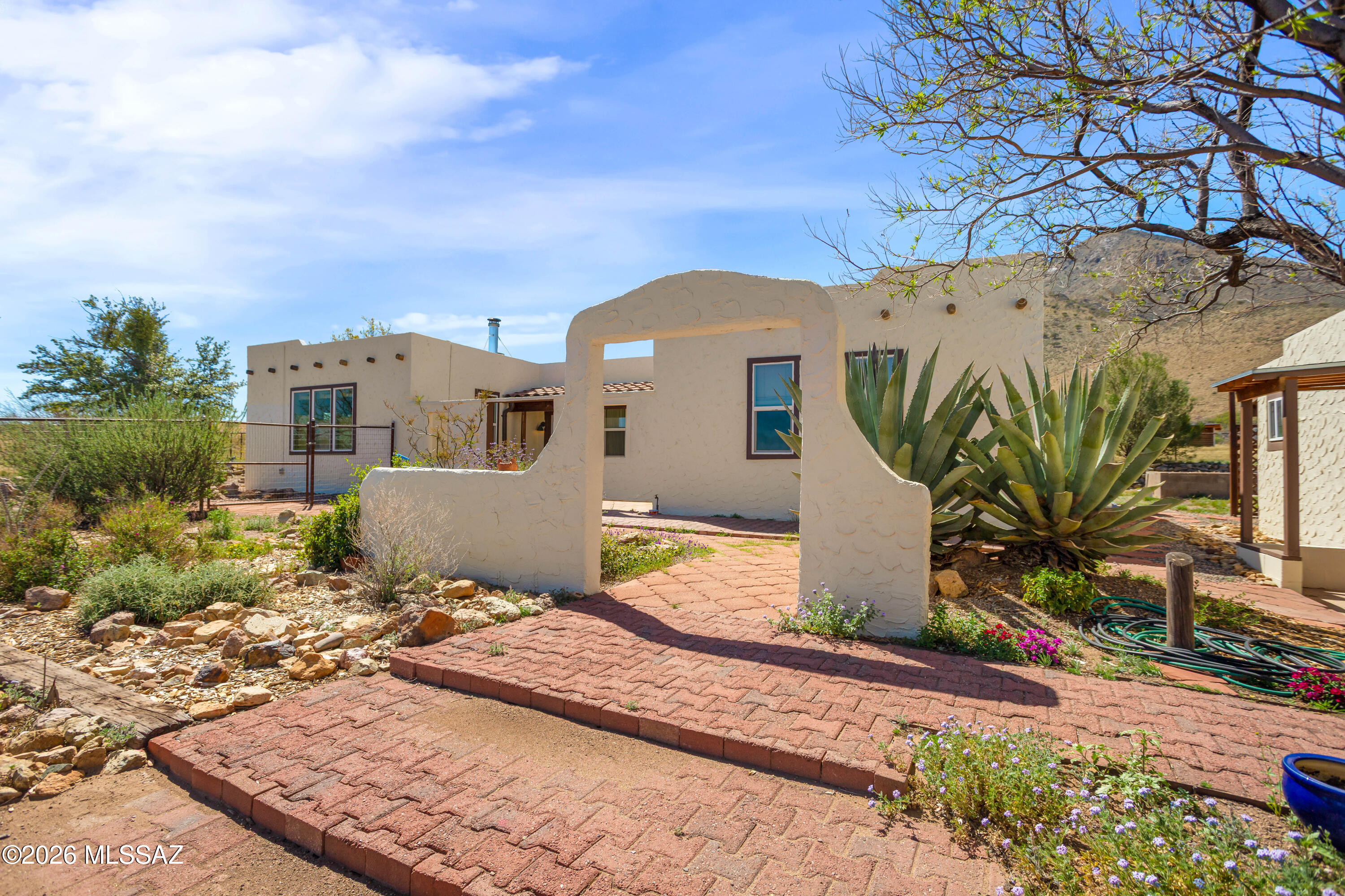 Unique 1bdr/1bath home located on over 15 acres of horse property offering wide open views.
Once inside you'll find large open concept living area that connects to a spacious kitchen, both perfect for relaxing and entertaining. 
French doors off the living room lead to a bright AZ room with a mini-prep area and an inviting fireplace. 
Out-front take in the view from the large open courtyard with several native plants, while out back you can unwind on the covered patio. A detached garage sits next to the home with a walkway leading to the fenced back yard which includes a shed and horse stall.
Entrance to the property is secured with an automatic drive through gate as well as a separate walk-through entry.
A rare find, with distinctive features and plenty of charm-this home is one of a