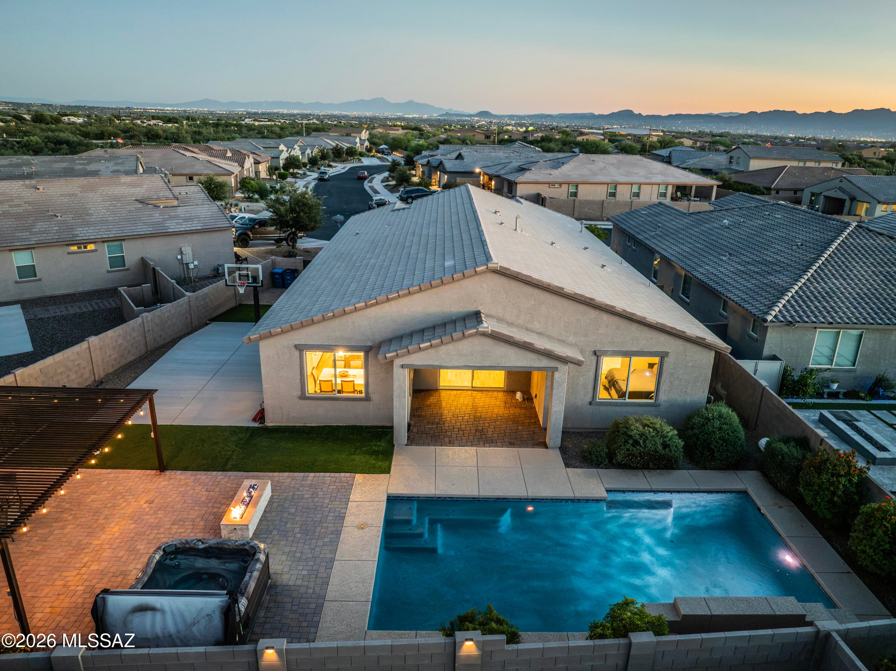 MOUNTAIN VIEWS with POOLSIDE LIVING and all the ROOM TO LIVE BIG! Welcome to Saguaros Viejos, where exceptional desert living meets resort-style luxury. Nestled within a desirable gated community between the Catalina and Tortolita Mountains, this stunning 4-bedroom, 3-bathroom home plus a Den/Bonus room sits on one of the community's larger lots, offering beautiful mountain views, room to spread out, and an incredible backyard designed to impress. The sprawling Sparrow floor plan features a desirable triple-split bedroom layout, creating the perfect balance of privacy and flexibility for family, guests, or working from home. At the heart of the home, the beautifully appointed kitchen showcases crisp white cabinetry, quartz countertops, an oversized island, and abundant pantry storage... flowing seamlessly into the expansive living space. Let's move outside and discover your own private backyard oasis. A sparkling heated PebbleTec pool with a water feature sets the stage for unforgettable Arizona days, while the hot tub, gas fire pit, and built-in gas BBQ and bar create the ultimate setting for entertaining. Relax beneath the lighted ramada, enjoy the mountain views, or shoot some hoops on your own basketball court. This is where everyday living feels like a vacation. Thoughtful upgrades elevate the experience even further, including a new 5-ton AC installed in 2025, a 3-car tandem garage with epoxy flooring, custom storage cabinetry and workbench, water softener, remote-controlled window coverings, security system with two cameras, and a custom metal front screen door. Beyond your front door, enjoy the lifestyle that makes Saguaros Viejos so special with its Ideal located near shopping, dining, parks, trails, golf and everyday conveniences, this exceptional home offers the perfect blend of luxury, comfort, and the sought-after Oro Valley lifestyle...A backyard that wows. A lifestyle that inspires. A home you'll love to come HOME to.