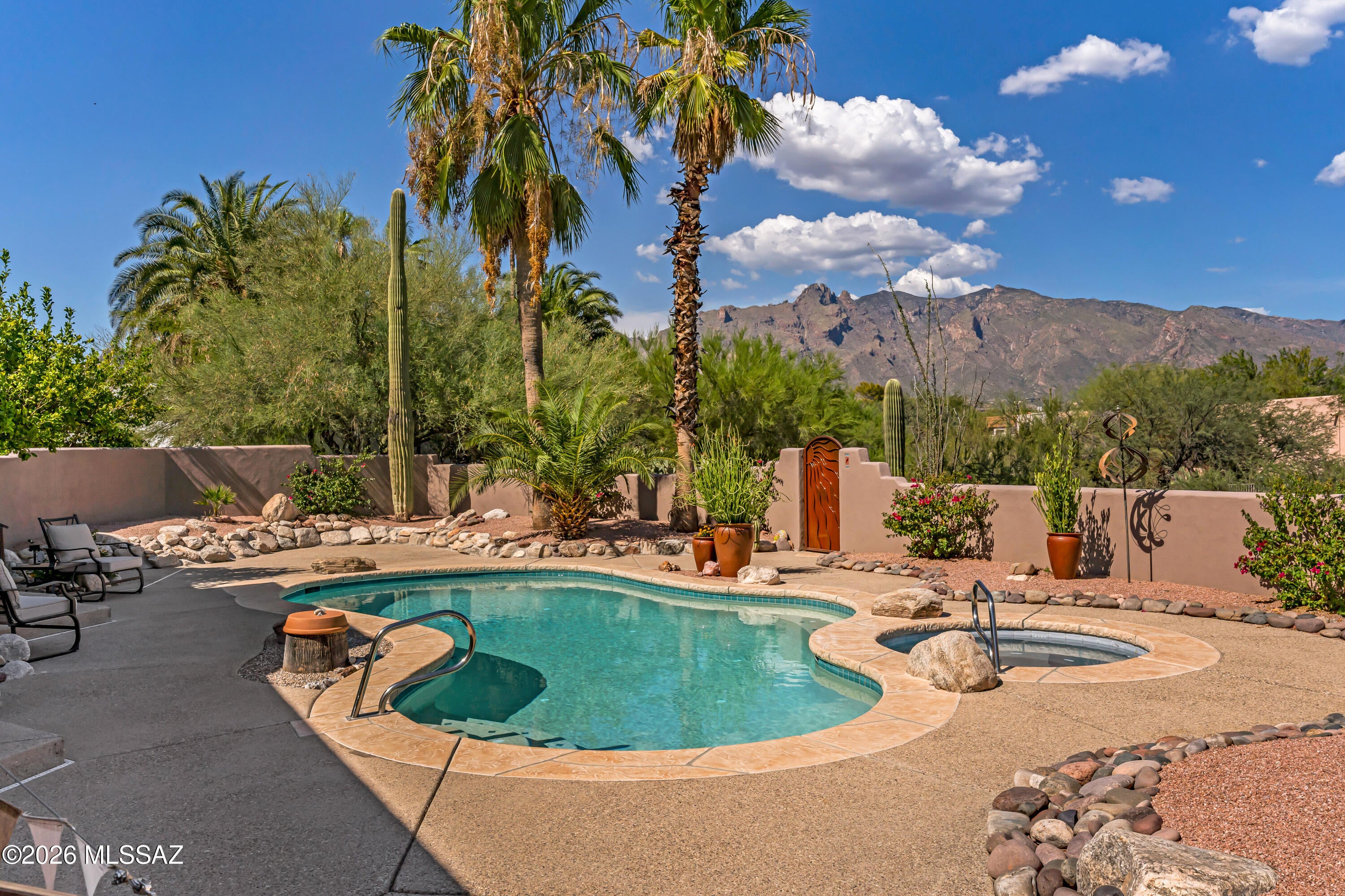 Set on a private 1-acre lot in prestigious Catalina Foothills Estates 7, this soft contemporary residence captures majestic mountain, desert & city views enjoyed from nearly every room. No steps! The thoughtfully designed split floor plan offers 3 bedrooms & a den/exercise room, two fireplaces, and a beautifully remodeled gourmet island kitchen with custom alder cabinetry and quartz countertops. Rich cherry wood floors blend seamlessly with classic Saltillo tile. Extensively and intentionally renovated with exceptional craftsmanship and high-end, eco-conscious materials, every detail has been thoughtfully curated - from Sierra Pacific sliding doors, argon-filled suncoated low E-windows, all custom cabinetry in new remodeled bathrooms, heated saltwater pool, new copper/PEX water pipes. ..EV charger, and much more (see long list of new/recent Improvements). Ideally located in close proximity Banner-University Medical Center, the UofA, premier hiking, golf, fine dining, and shopping.