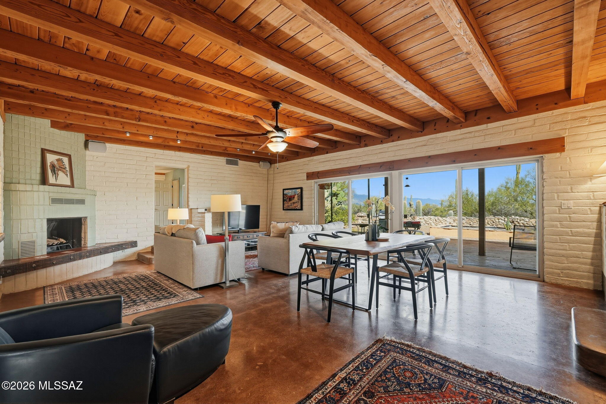 This classic midcentury modern home on over 2 acres of sahuaro studded natural desert with gorgeous mountain views epitomizes the iconic beauty of  the timeless Sonoran Desert. Large windows and an extended patio provides stunning views and wildlife watching in privacy.  A split bedroom plan, open beamed ceiling, concrete floors and a wood burning fireplace gives a rustic yet modern feel. The main house is completely energy efficient-new owned solar panels on a new roof and new electric heat pump system means no electric bills. Owner only pays for water.  There are 3 rainwater harvesting cisterns on the property as well as a gray water system to water the outdoor plants. The separate casita can be an artists studio, guest home or a rental.  Has it's own covered parking and charming patio.