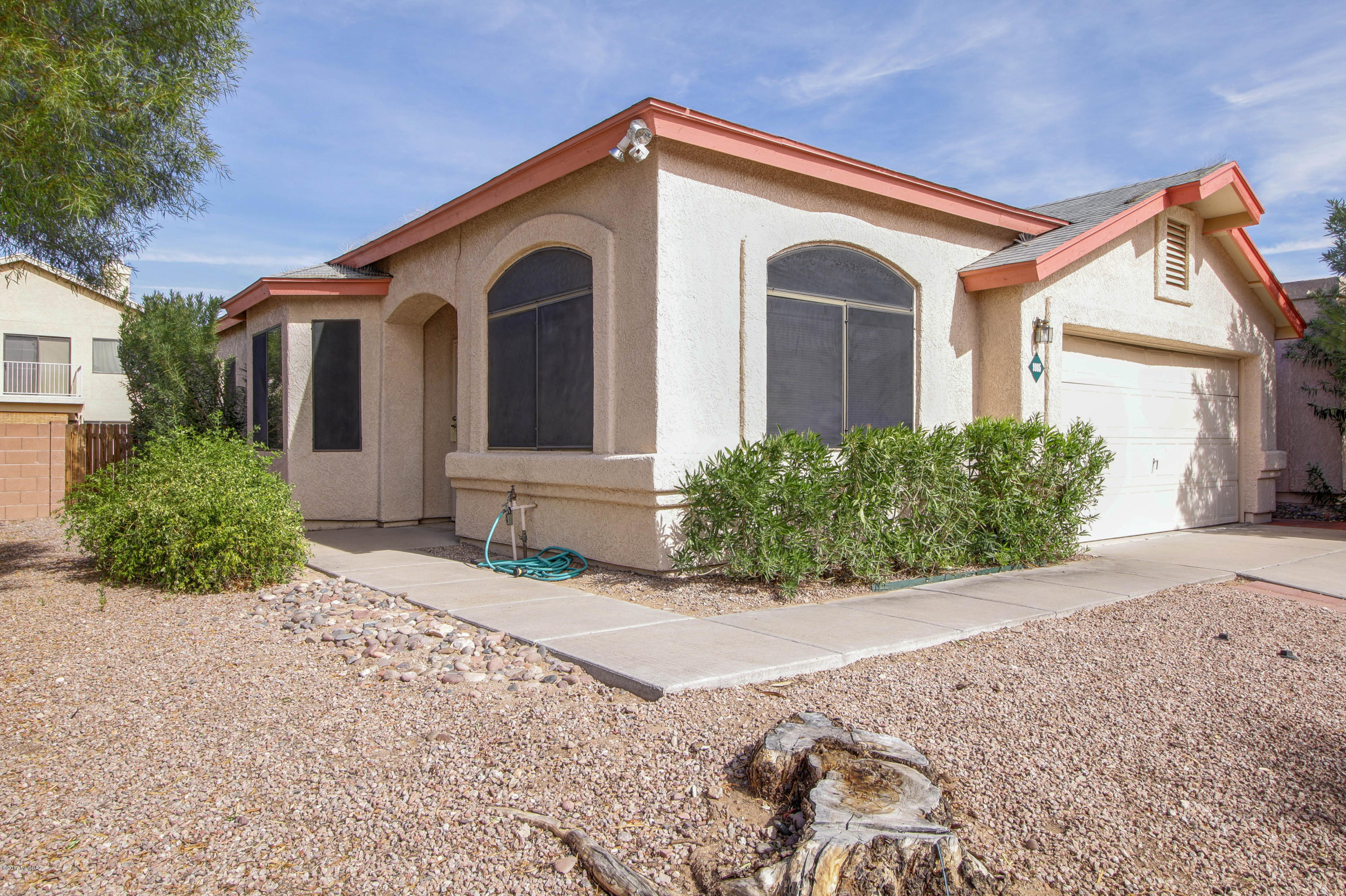 Beautiful home in Rita Ranch Hacienda del Oro. Features Living/Dining, Great Room, Breakfast Bar. Bedroom 2 is double-sized and has a super closet! Bedroom 3 near entry would make a good office as well with lots of built-in shelving.Wood laminate flooring. Double doors and carpet in each bedroom. Refrigerator, washer/dryer included. Pantry closet and cabinet. Dry bar in living room. Laundry room cabinets. Extended covered patio. Concrete and pavers in backyard. Dog run. Easy care landscaping. Security doors. Garage service door to side yard. Cox high speed internet. Close to schools, parks, shopping, Tech Park, DMAFB, I-10 & Sonoita Hwy 93. Vail School District. A MUST SEE!