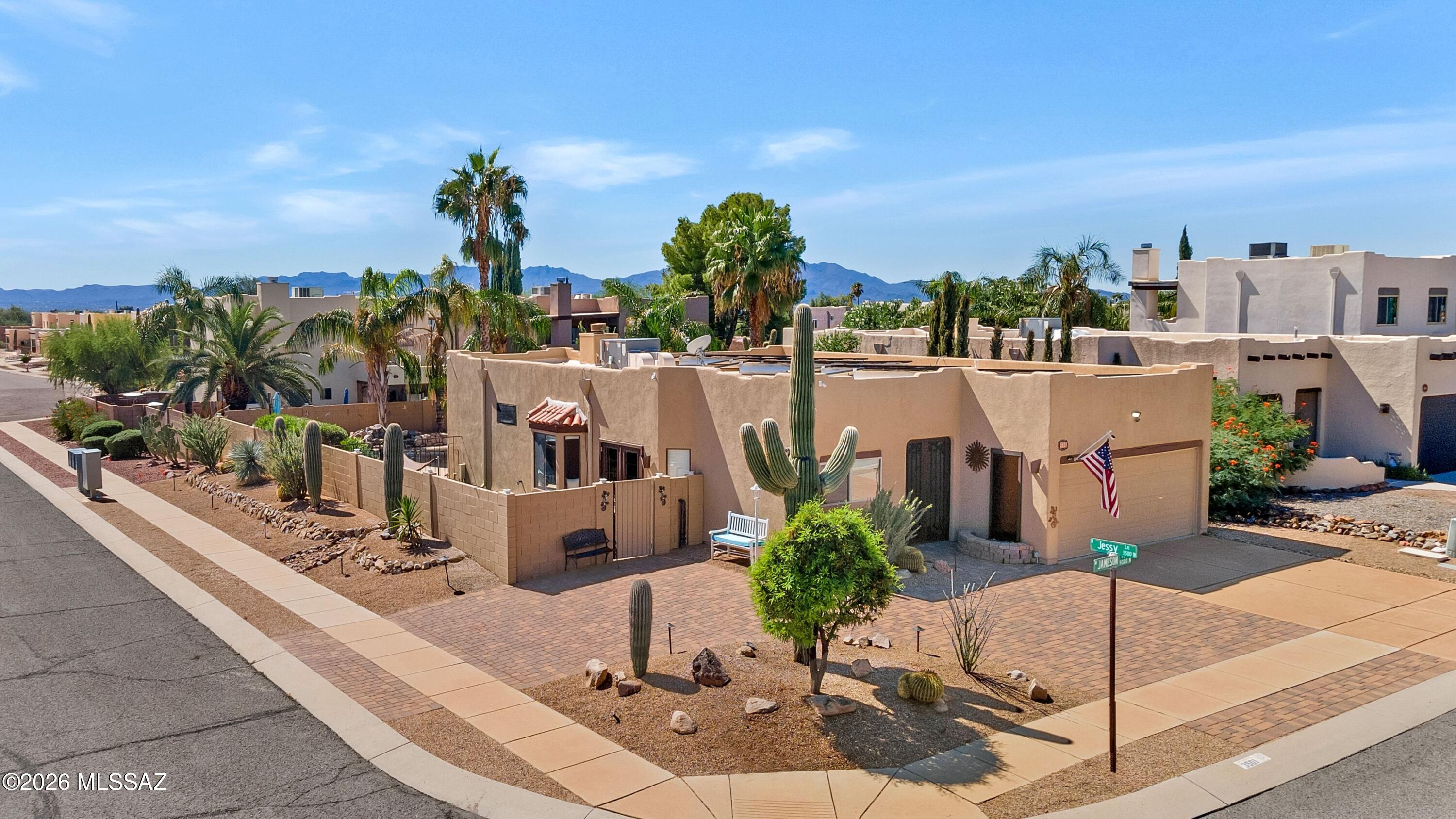 Welcome to this Santa Fe home. A pavered circle drive sets the tone before you even step inside. You will be greeted by a large front door, tall ceilings, travertine tile, and an open great room made for gathering. The partially updated kitchen sits at the heart of it all, ready for weeknight dinners and holiday crowds alike. The split floor plan gives the primary suite a true retreat feel. Its spa-inspired bath features quartz counters, stacked stone, knotty alder cabinetry, and a custom glass shower with travertine surround and rain showerhead. The guest bath carries the same quality, with quartz, travertine, and a striking copper sink. Step outside and the private backyard becomes your own resort. Float in the Pebble Tec pool beside the waterfall, fire up the pizza oven in the outdoor kitchen, or gather around the firepit as the desert sky turns gold. The covered patio and bar area make entertaining effortless, from Saturday BBQs to quiet evenings for two. The hot tub will convey with the sale. Even the garage is thoughtfully finished with epoxy floors, air lines, and extra outlets. Add solar, a tankless water heater, a security system, and many more upgrades, and this turnkey home truly is the one you've been waiting for.