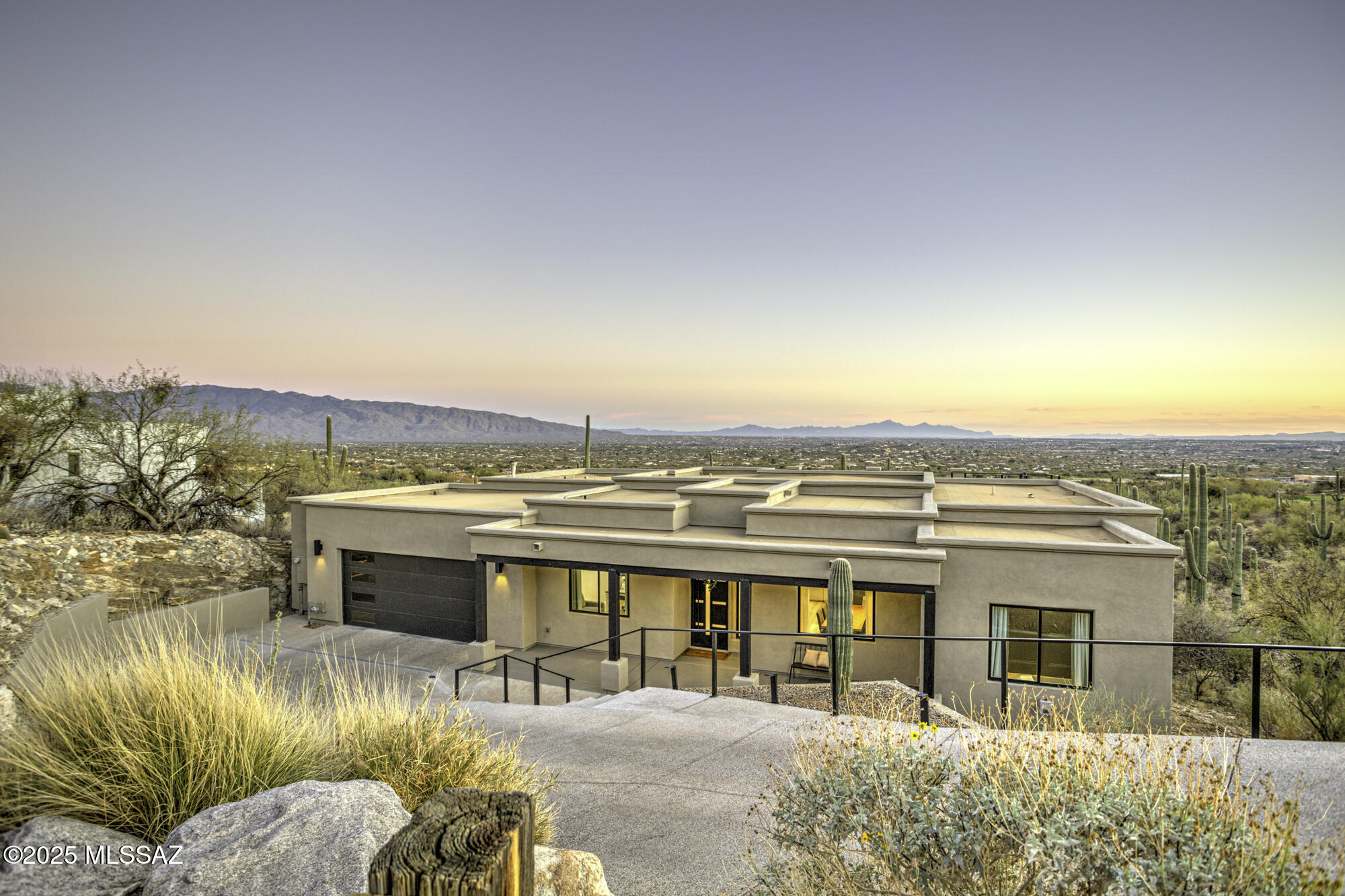 Nestled above the renowned Arizona National Golf Course within the exclusive, guard-gated Sabino Springs community lies the epitome of privacy and luxury - Sabino Estates. This remarkable residence offers unparalleled panoramic vistas, showcasing the city's skyline, majestic mountain ranges, stunning sunsets, and the prestigious 16th Green.  At just one year old, this home exudes every modern elegance, featuring soaring 12-foot ceilings, grand 8-foot doors, and exquisite quartz countertops throughout. The custom-designed fireplace, complete with media prewiring, creates an inviting atmosphere, while the dedicated office space offers flexibility, easily convertible into a fifth bedroom if desired. The split-bedroom layout presents an expansive primary