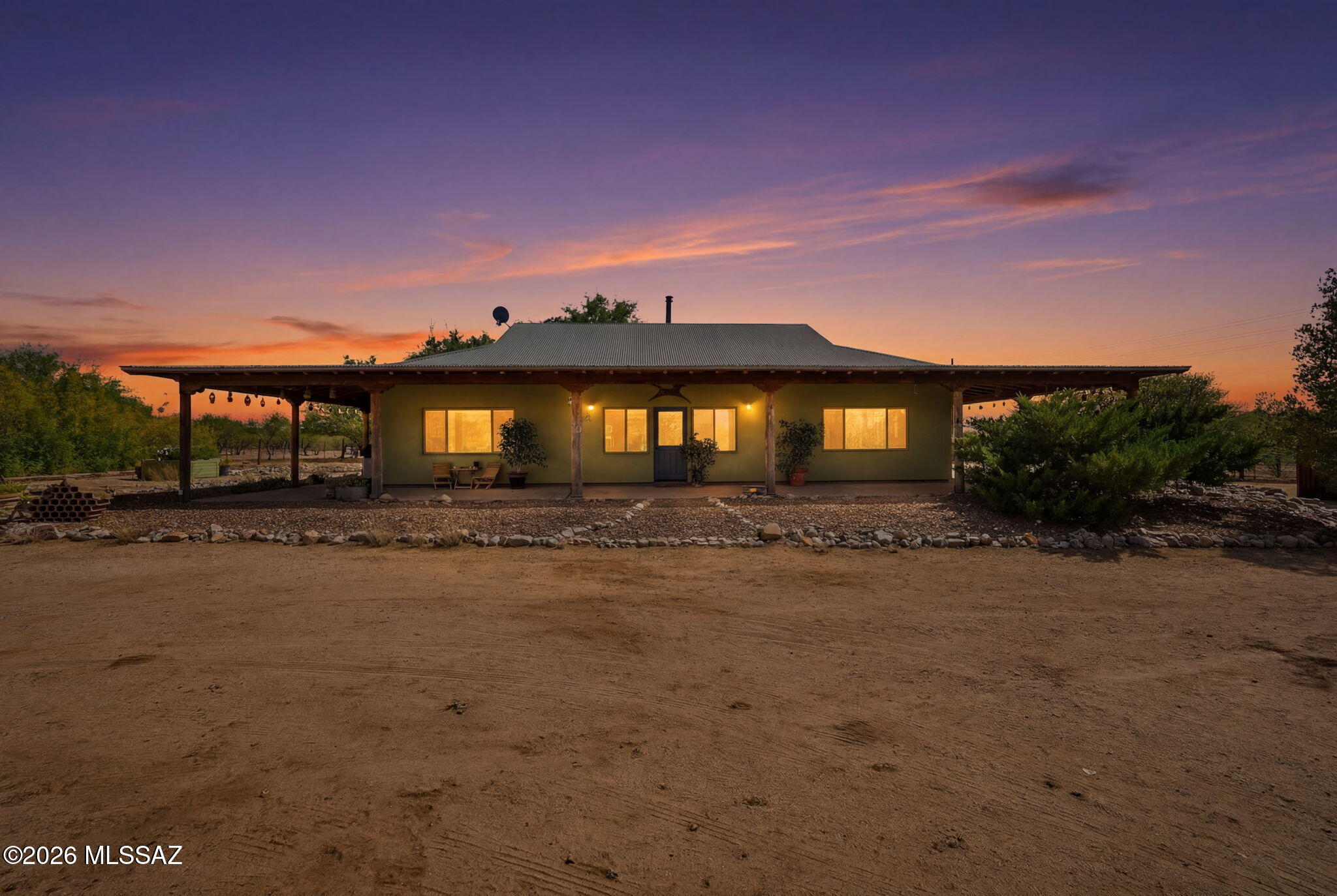 Live the Arizona Ranch Lifestyle You've Always Dreamed Of! Every great story begins with a place that feels like home--surrounded by  nature and designed for living. Situated on just over five fully fenced acres with breathtaking mountain views, this custom-built 2x6 ranch home with compressed foam panel insulation blends exceptional craftsmanship with the peace and freedom of country living. Wake up to spectacular sunrises, enjoy frequent visits from quail, deer, and a resident owl family, then end the day beneath unforgettable Arizona sunsets. Built for lasting quality, the home features a durable metal roof, updated copper and PEX plumbing, a new HVAC system (2023) with warranty, city water for the home plus a private irrigation well, propane for heating and cooking, an electric water heater that is already plumbed for propane, a propane clothes dryer, leased solar (buyer to assume), satellite internet, and a septic system. Inside, rustic elegance shines with knotty alder cabinetry, distressed copper countertops, a copper range hood, a marble-topped center island, and a professional-grade FiveStar propane double-oven range. The open living room is anchored by a beautiful soapstone wood-burning fireplace with pine shiplap accents, while stamped concrete floors and tiled showers add timeless character throughout. A spacious laundry room with utility sink makes everyday living effortless. Step outside to the expansive wrap-around covered porch with aggregate concrete patio--the perfect place for morning coffee, outdoor entertaining, or simply soaking in the surrounding beauty. Designed with horse lovers and outdoor enthusiasts in mind, the property also includes a horse arena, three rebuilt horse stalls with tack room, RV parking with clean-out, and an attached workshop with carport, 220-volt outlet, and potential to accommodate up to three vehicles with modifications. Four gated entrances and no HOA provide the flexibility to truly enjoy your land. Just minutes from shopping, dining, and everyday conveniences, this remarkable ranch offers the rare opportunity to enjoy country living without sacrificing access to town. Bring your horses, your hobbies, and your dreams--this is Arizona living at its finest.
