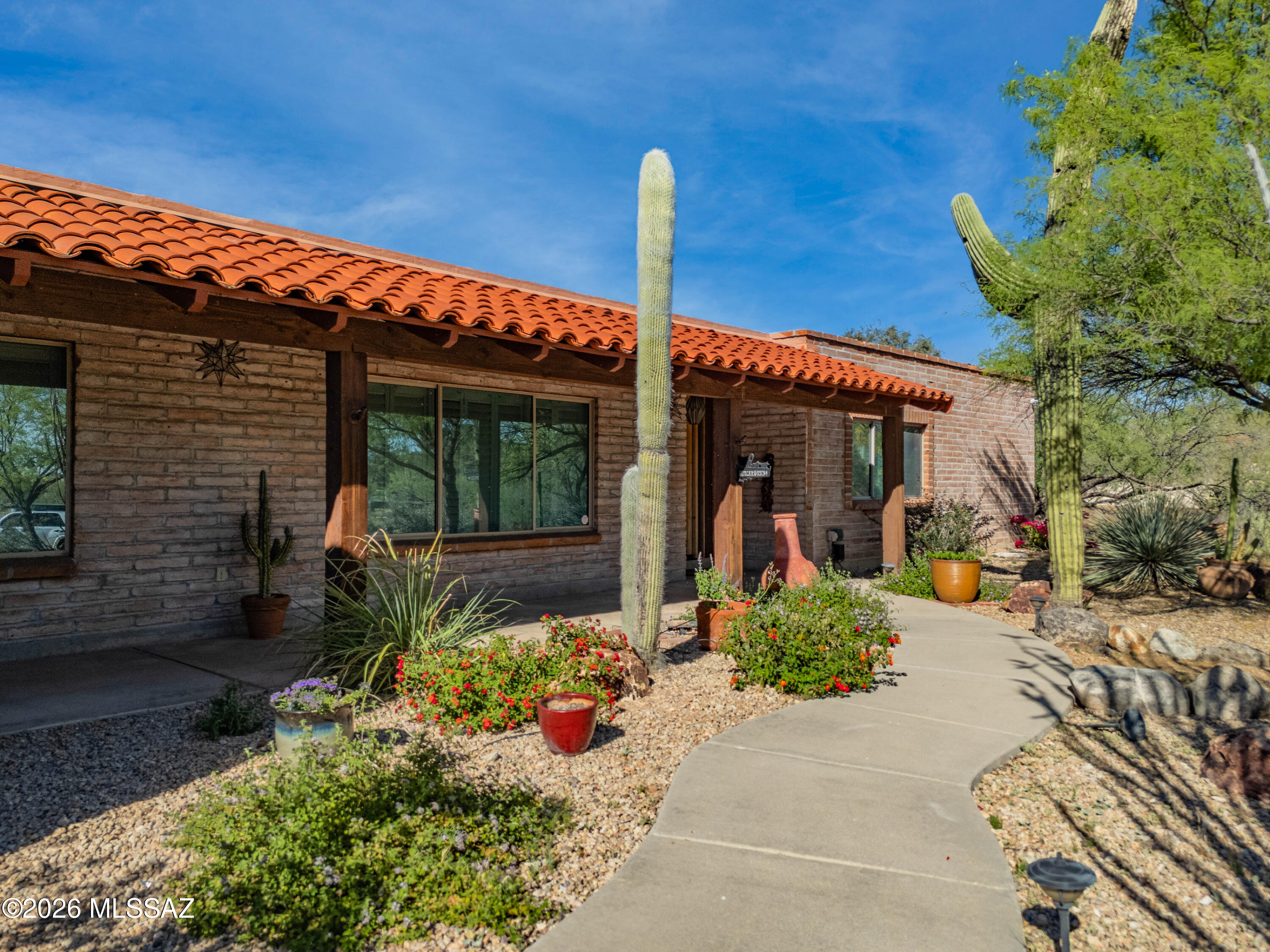 This stunning 3,246 square foot home sits on over an acre of lush, private grounds with incredible views of the Catalina Mountains. The spacious 5 bedroom, 3 full bath layout features beamed ceilings and a chef's dream kitchen perfect for entertaining. The large storage room, 3-car garage,  separate office and large bonus recreation room provide abundant storage and living space. Step outside to the backyard oasis, complete with a shed and endless opportunities to enjoy the beautiful mountain views.  There is a large ramada with sink, natural gas and counterspace, updated salt water pool, and gas fire pit under the trees.  This home is perfect for entertaining and backyard parties.  Owner is a licensed real estate agent in AZ.
