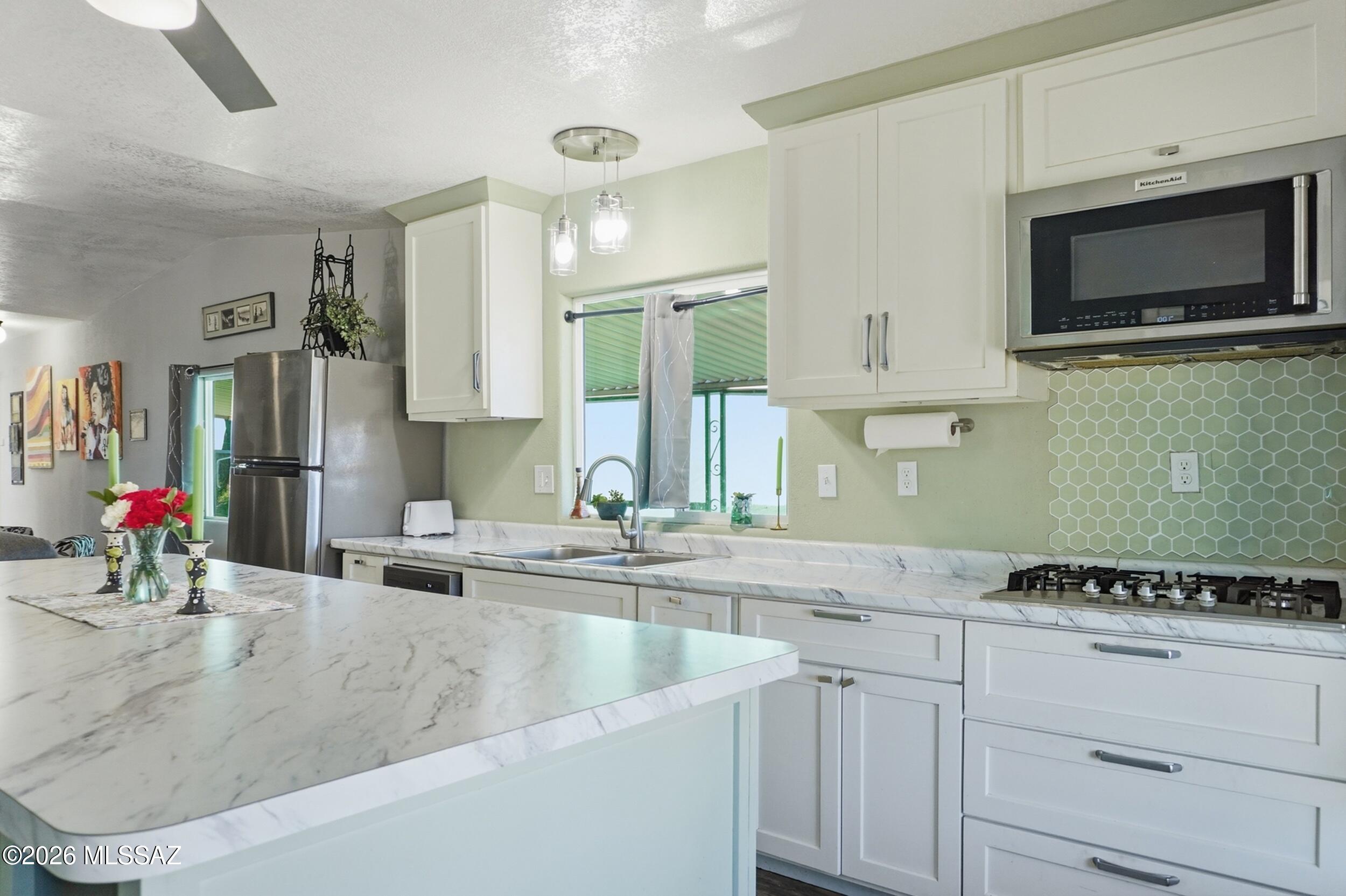 Freshly updated 2-bedroom, 2-bathroom home offering approximately 900 sq. ft. in the gated Rincon Valley 55+ community on leased land. The open-concept interior features luxury vinyl flooring, newer windows, updated lighting, and a remodeled 2022 kitchen with an impressive 8.5' x 3.8' island. The spacious primary suite includes a flexible office area, while the second bedroom has a private exterior entrance--ideal for guests or hobbies. All appliances include a 2-year warranty. Enjoy citrus trees, rose bushes, two pools, tennis, pickleball, clubhouse activities, dog park, grilling area, Health Shed, gated entry, and wellness checks. Monthly lot rent is $758. Call for details, financing information, or a private tour!