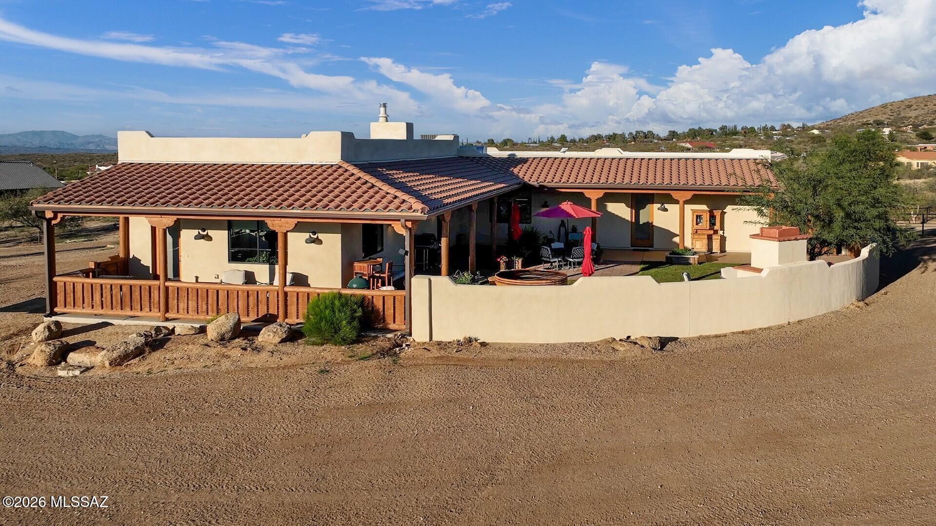 ASSUMABLE 3.5% LOAN!! Sellers will entertain offers between $949,000 and $1,025,000. Call for details. Tucked away in small-town America, at the northern foothills of the Santa Catalinas the old mining town of Oracle is a visitors' outdoor activity destination, dotted with coffee cafes, pubs, eateries, a gourmet grocer & bakery & other essentials. Inside, the custom solid quality home blends lodge-style design with rustic sophistication. Rich wood accents, large picture windows & 8' glass doors throughout create a seamless connection to the stunning unobstructed mountain landscape. Entertain or relax in the inviting courtyard with 1,250sf of covered patio & oversized fireplace; or indulge your culinary talent in the inspirational, professionally designed & appointed kitchen, boasting newer high-end Viking & Thermador appliances and abundant natural stone counters atop custom wood cabinetry and a pantry. The split layout offers two oversized bedrooms plus a flexible bonus room that easily becomes an office, guest space, fitness room, or studio. Bathrooms are finished with quartz double-sink vanities, porcelain tile and spacious zero-threshold showers. At nearly 4,500 feet elevation, where the temperatures are consistently 10 degrees cooler than Tucson, Oro Valley, Marana and Tanque Verde, this property is where horses thrive, featuring thoughtfully executed equestrian facilities on the fully fenced and gated land, which were designed for the climate, efficiency and safety. The stables includes a barn with 5 oversized stalls, a tastefully appointed tack & feed room, pipe-fenced turnouts and separate exercise paddock. Beyond your fence line, a vast 750,000 acre network of hiking, biking and riding trails awaits in the State and National Forest lands, accessible directly from your property, giving this all-usable 3.34-acre equestrian retreat the kind of freedom and privacy for anyone craving space, solitude and the quintessential Arizona lifestyle in a relatively low-maintenance format, while still within reasonable distance to the University, businesses, shopping and services.  An outdoor shower, aromatic cedar spa, and two full RV hookups round out this amazing property. This home has full homeowners insurance for $1,385 per year. Come visit this impeccable, cultured comfort in Oracle. You'll be glad you did!