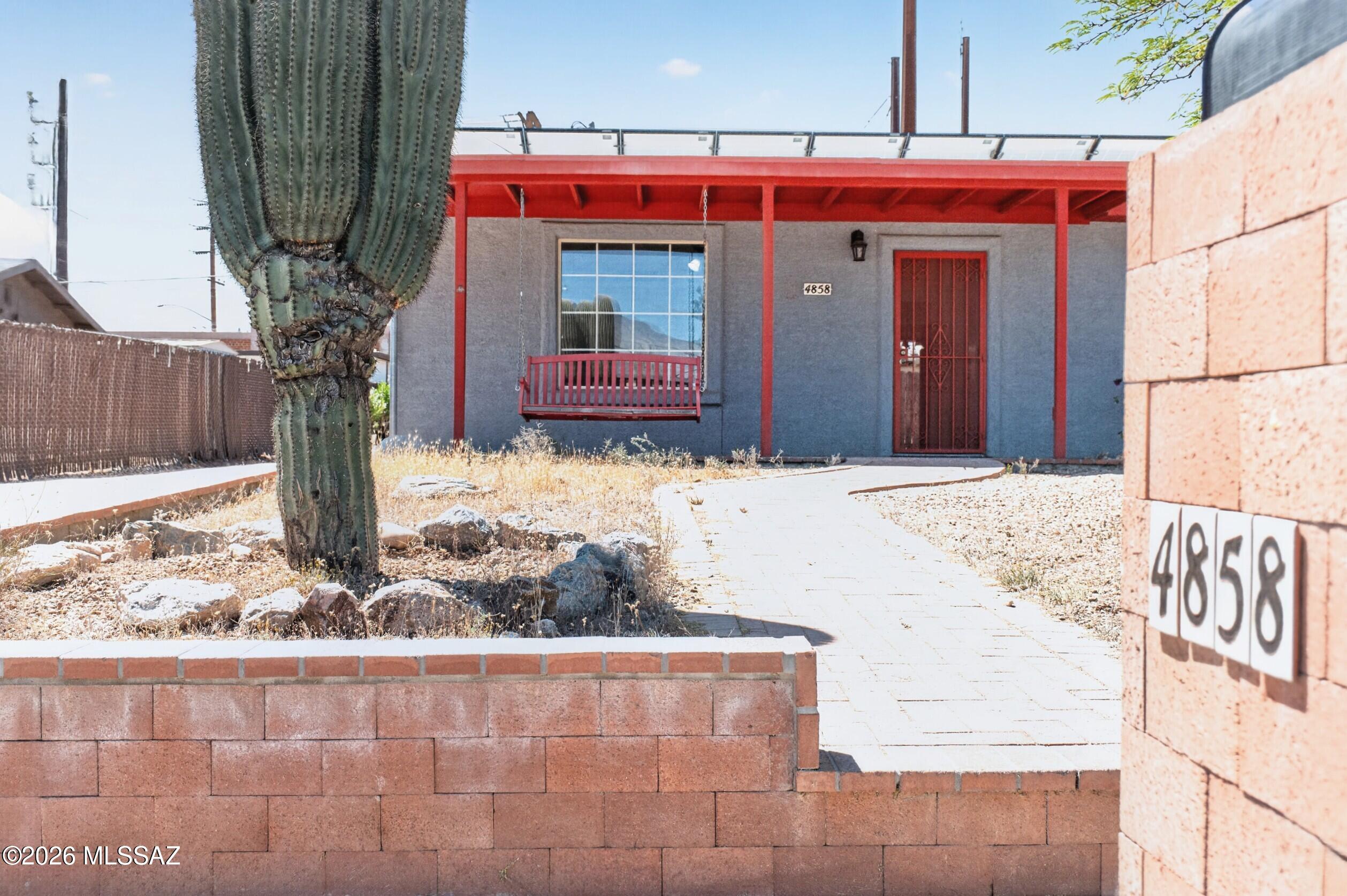 Welcome home to this charming, upgraded ranch-style retreat in a sought-after Central Tucson neighborhood. A covered front porch with red wood beams, porch swing, and blooming bougainvillea creates a warm first impression. Inside offers 1,504 sq ft of single-story living with ceramic tile flooring, a floor-to-ceiling fireplace, and a bright neutral palette. The galley kitchen includes dishwasher, disposal, and refrigerator, opening to living and dining areas. A standout bonus room with private entry is ideal for guests, office, or rental use. Enjoy a covered patio with red beam accents and a built-in brick BBQ with stainless grill--perfect for relaxing or entertaining.