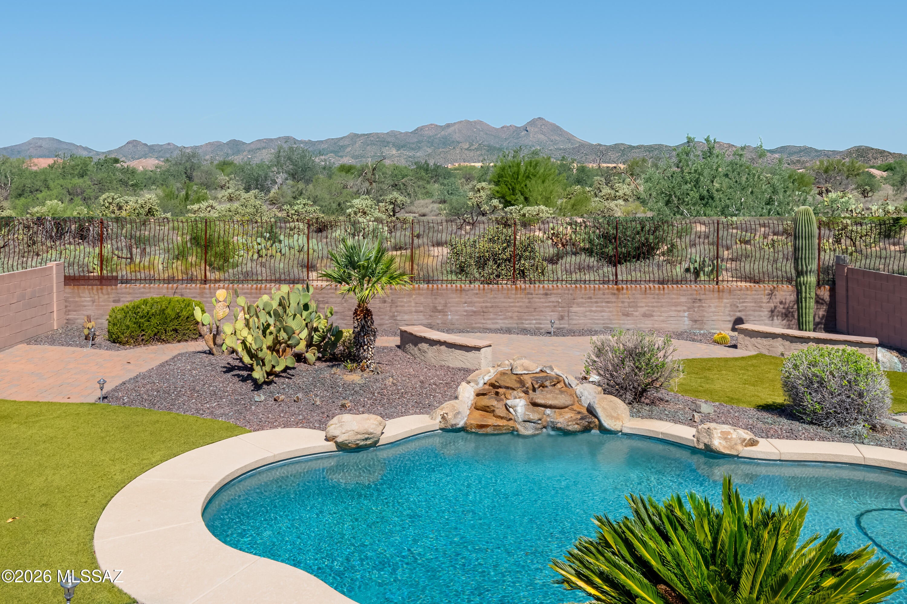 Located in the highly desirable gated community of Hohokam Mesa in Rancho Vistoso, this exceptional 2,651sf 4BR/2½BA+den & Arizona room single-story home sits on premium lot w/beautiful Catalina Mountain views combining open-concept floor plan, quality finishes & resort-style backyard w/pool. Brand new HVAC installed Sept 2026. Spacious great room has corner fireplace and is open to well-appointed kitchen, creating the perfect setting for everyday living & entertaining. High ceilings, expansive windows & inviting layout enhance the home's bright, open feel, while the desirable split-bedroom floor plan provides privacy for both owners & guests. Versatile den offers flexibility for a home office, media room, fitness space, or hobby room. The resort-style backyard is designed for year-round Arizona living, featuring a sparkling pool, expansive paver patios and walkways, lush artificial turf, mature desert landscaping, and Catalina Mountain views. The pergola covered patio provides the perfect setting for outdoor dining and entertaining, while the premium lot with no direct rear neighbors offers exceptional privacy and tranquility. Ideally located in one of Oro Valley's premier master-planned communities, Hohokam Mesa is surrounded by the natural beauty of the Sonoran Desert and offers convenient access to Hohokam Park, the Vistoso Trails Nature Preserve, miles of walking and biking trails, golf courses, shopping, dining, entertainment, medical facilities, and top-rated schools. Whether you're searching for a full-time residence, seasonal retreat, or lock-and-leave home, this exceptional property offers the perfect combination of luxury, comfort, privacy, and location.