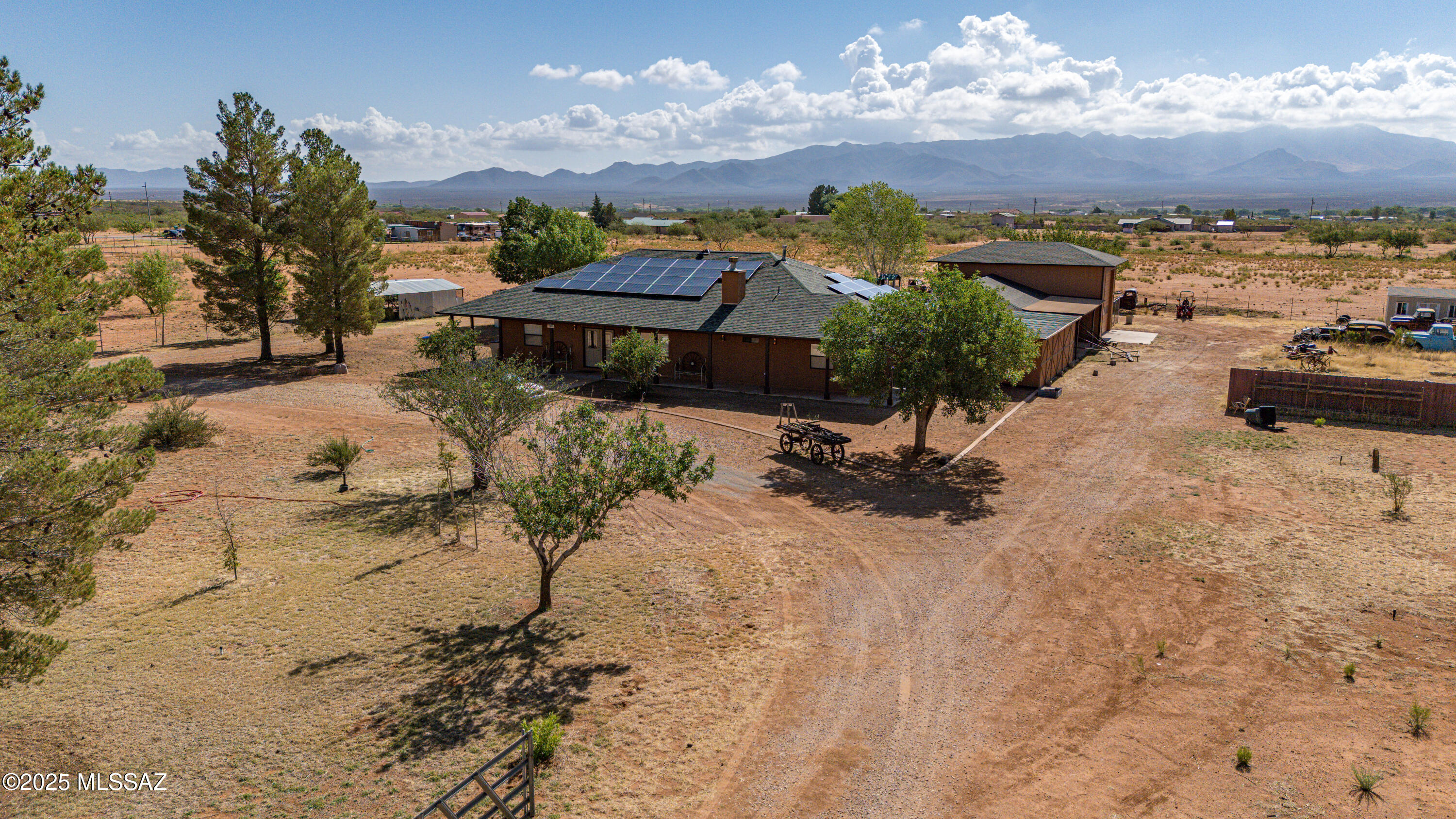 Discover the perfect blend of space, privacy, and convenience on this fully fenced 8.4-acre property with sweeping mountain views. Ideal for those who value peace, self-sufficiency, and room to grow, this property checks all the boxes.The 3-bedroom, 2.5 bathroom home features an additional den, ideal for a home office or guest space. The kitchen boasts granite countertops, ample cabinetry, perfect for entertaining or daily living. Car enthusiasts, hobbyists, and RV owners will love the incredible garage space: a 5.5-car garage, a dedicated RV garage with full hookups, plus a separate workshop for tools, projects, or storage. Solar power and enjoy the freedom of your own private well. A newer roof. Step outside to enjoy your own private oasis?featuring fruit trees, a greenhouse.