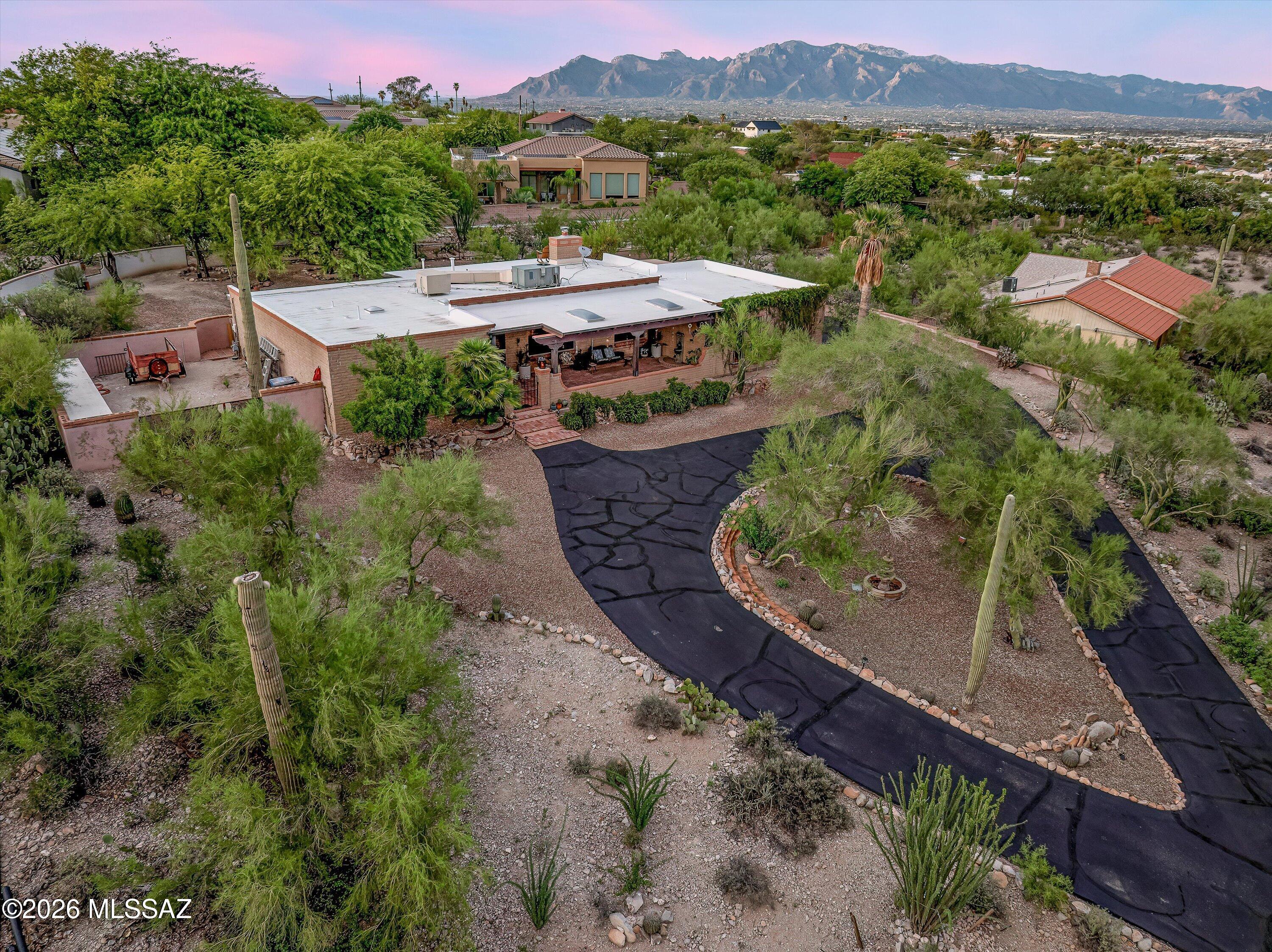 A Desert Dweller's Dream

Perched on a rolling hill on 1.06 acres of natural Sonoran Desert and nestled in one of Tucson's iconic West-side neighborhoods--known for its unique character, privacy, expansive views, and rugged desert beauty--this gorgeous 2,121 sq. ft. Territorial abode radiates warmth and comfort. Lovingly maintained and thoughtfully updated over the years, your new 3Bed, 2Bath home with a 2-car garage, additional carport, and gated RV parking packs all the charm that is expected from Tucson living.
A winding driveway, lush natural desert landscaping, and carefully stacked rock walls guide you home. A circular design creates the perfect setting for a center fountain and bench, inviting you to sit, unwind, and soak in the beauty of nature while enjoying views of the Tucson Mountains. An ample custom front porch beckons your presence and immediately sets the tone for the peaceful living experience that awaits. Whether enjoying your morning coffee, watching dramatic summer monsoon storms roll across the valley, or ending the day beneath Tucson's unforgettable sunsets, every moment celebrates the beauty of the Sonoran Desert.
Enter to stunning views of the Tucson Mountains framed by Andersen picture windows from both your Living/Dining rooms! Elegant tile floors and pristine engineered wood flooring elevate the space, while abundant natural light and an open, flexible floor plan provide ease of everyday living and effortless entertaining.
Enjoy a chef's kitchen complete with custom cabinetry, a grand center island, double sink, and a large skylight with an automated blind that allows you to adjust the natural lighting to your preference throughout the day. Perfectly positioned at the center of the home, the kitchen enjoys direct access to every living space, making it ideal for gathering with family and friends.
A comfortable family room becomes the natural gathering place on cool desert evenings as the brand-new gas fireplace (2025) emits warmth and creates a peaceful ambiance. From this vantage point, the majestic Catalina Mountains serve as a breathtaking natural backdrop, creating a view that changes beautifully throughout the day.
A grand primary ensuite offers the perfect place to unwind while enjoying subtle yet beautiful mountain views. Beautifully updated in 2018 and enhanced in 2026, the spa-like bathroom features a stunning glass shower, Delta fixtures, a large vanity with dual mirrors and updated vanity lighting, and an elegant tile surround. Two spacious closets, a linen closet, and enough room for a cozy reading nook make this personal retreat as functional as it is relaxing.
Two additional bedrooms enjoy views of your magnificent backyard and are both spacious, bright, and welcoming. The hall bathroom offers all the tasteful updates found in the primary bath, plus a freshly resurfaced tub, creating a cohesive feel throughout the home.
Immerse yourself in nature as you spend countless hours enjoying cool desert breezes from your backyard oasis. An extensive covered patio, fully fenced backyard, thoughtfully designed landscaping, and an elevated viewing spot come together to create an unforgettable outdoor experience. Whether gathering with family and friends, relaxing with a good book, or firing up the grill, every space was designed to embrace the surrounding desert and sweeping valley views. Even your grilling area enjoys a front-row seat to the spectacular scenery.
Need more space for vehicles? The additional carport provides exactly that. Looking for room for an RV, trailers, work equipment, or recreational toys? With no HOA, you're free to bring them all. A double gate leads to a dedicated RV parking area along the side of the home, while built-in storage cabinets help keep tools, materials, and equipment organized and protected.
Thoughtful improvements throughout the home provide beauty, functionality, and peace of mind. A new electrical panel (2025) offers confidence for years to come, while the new gas fireplace (2025) adds warmth and efficiency. Andersen picture windows beautifully frame the surrounding landscape while enhancing energy efficiency, and the engineered wood flooring brings timeless character to the living spaces. Beautifully updated kitchen and bathrooms, including the refreshed guest bath with its resurfaced tub, reflect the care invested throughout the home. (See the complete Updates List for additional improvements.)
This is not your typical two-car garage. Fresh polyaspartic floor coating elevates the space while the generous size allows for comfortable parking of two vehicles with room to spare. A 13.1' x 8' workshop area provides the perfect space for hobbies, projects, or additional storage. The laundry room offers convenient access to both the garage and family room, making everyday tasks--from unloading groceries to tackling laundry--effortless.
This distinctive home truly offers the best of everything: no HOA, an open floor plan, thoughtful updates, breathtaking mountain and valley views, expansive outdoor living areas, an additional carport, gated RV parking, and an undeniably spectacular setting.
The location is equally exceptional. Be in Downtown Tucson in less than 10 minutes to enjoy its vibrant restaurants, entertainment, shopping, museums, theaters, and the Mercado District. Just minutes away, Gates Pass offers one of Arizona's most scenic drives, leading you to Old Tucson, the Arizona-Sonora Desert Museum, and Tucson Mountain Park West.
Outdoor enthusiasts will appreciate immediate access to some of Tucson's finest trail systems, including Painted Hills, Sweetwater Preserve, Camino de Oeste, Gates Pass, and the Dave Yetman Trail. Whether your passion is hiking, trail running, mountain biking, road cycling, birdwatching, or simply enjoying an evening walk along Anklam Road or Camino de Oeste, this West-side location places you at the heart of it all.
The West Side of Tucson is treasured for its authentic Sonoran Desert landscape, protected open spaces, towering saguaros, abundant wildlife, spectacular sunsets, and the peaceful feeling of living surrounded by nature while remaining remarkably close to city conveniences. It is a lifestyle that few areas of Tucson can truly offer.
Convenient access to I-10, the University of Arizona, major hospitals, Tucson International Airport, Davis-Monthan Air Force Base, Caterpillar, Raytheon, grocery stores,Hospital,  dining, and everyday amenities means you're never far from where you need to be.
Take the time to stop and admire the ever-changing beauty of the Sonoran Desert. Watch monsoon storms roll across the valley, enjoy the golden glow of sunset over the Tucson Mountains, and experience the quiet magic that makes this part of Tucson so special.
This is a home you truly must experience in person.
