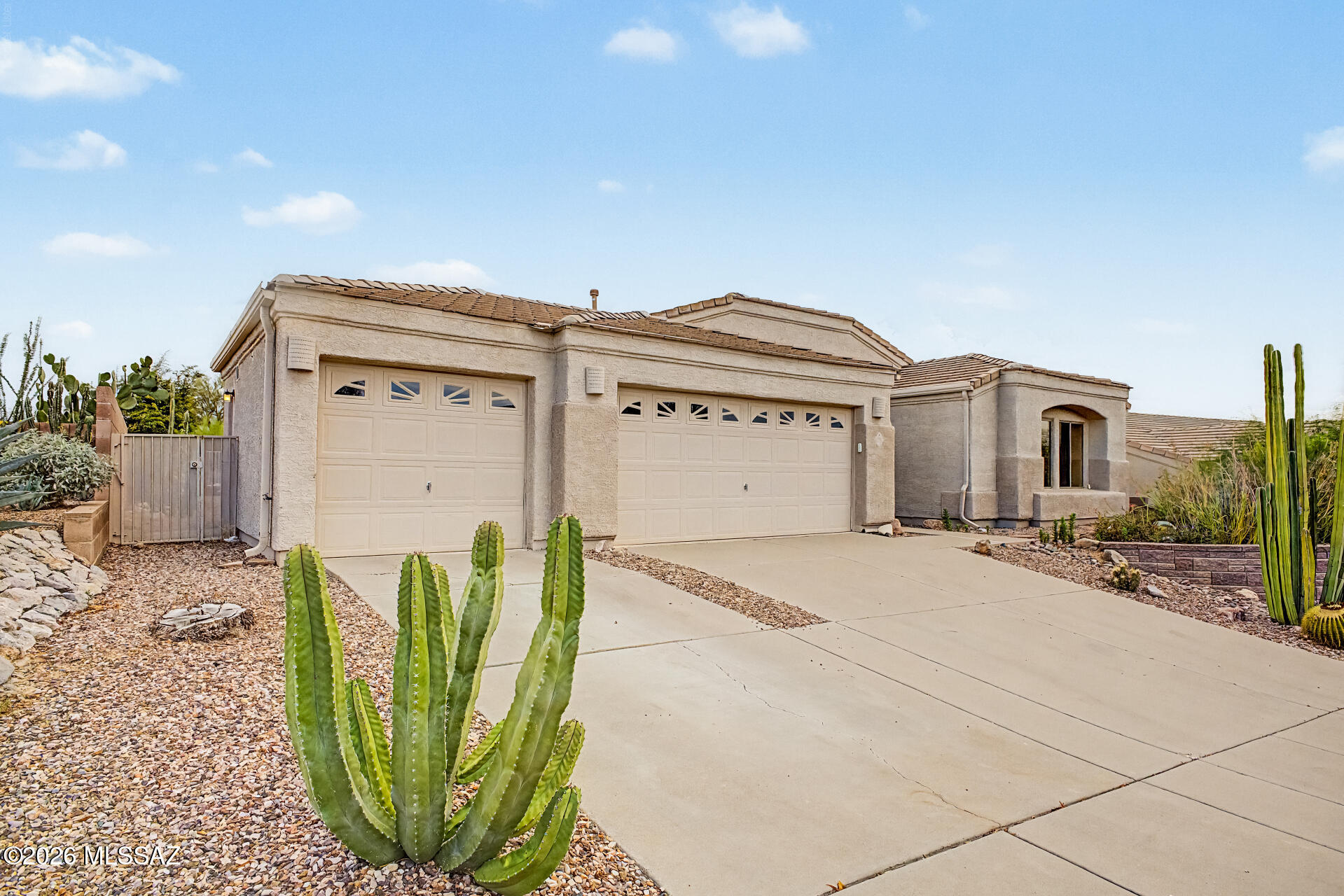 Mountain Views! This stunning 3-bedroom home welcomes you with a 3-car garage and a lovely desert landscape. Fall in love with the bright, spacious open layout featuring soaring vaulted ceilings, a soothing palette, blinds, wood-look flooring, and an inviting fireplace for cozy evenings. The gourmet kitchen comes with granite counters, ample wood cabinetry, recessed lighting, a tile backsplash, SS appliances, a pantry, and a peninsula with a breakfast bar. The primary bedroom showcases sliding door access to the backyard, an ensuite with double sinks, and a convenient walk-in closet. This property features two primary suites, both with private bathroom access. The is an optional 3rd bedroom w/closet or can be used as an office. Imagine enchanting evenings in the charming backyard, boasting a screened patio, a refreshing pool and spa w/working heater. A view fence offering breathtaking panoramic views of Catalina Mountain, Pusch Ridge and City lights. Property backs to a common area with hiking trails and is adjacent to Naranja Park.  Home features: pre-wired for media/surround sound, new water heater, exterior gas stub, electronic air filtration system, sealed garage, patio, and Arizona room floors, all in a low-traffic location. Make this gem yours!