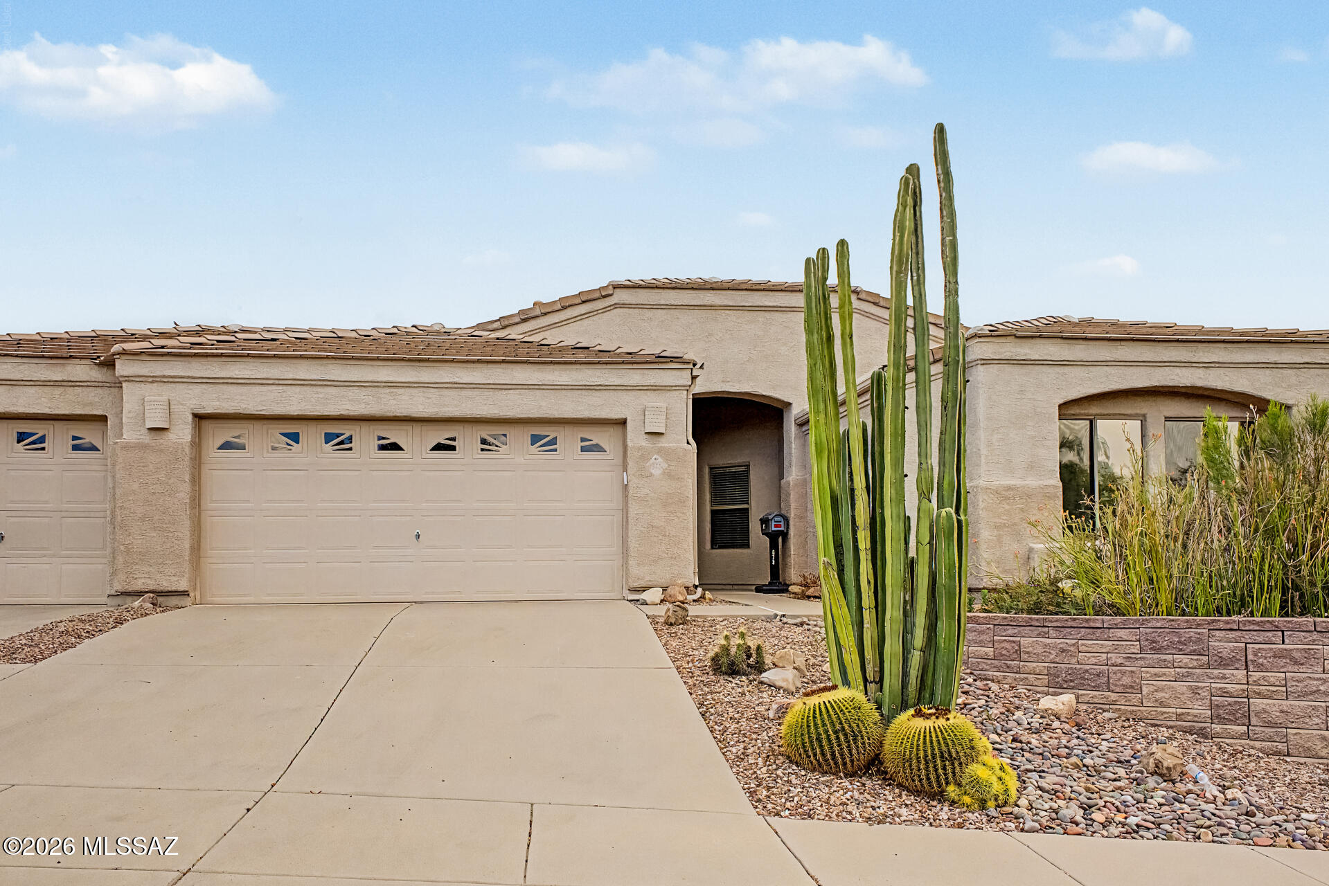 Mountain Views! This stunning 3-bedroom home welcomes you with a 3-car garage and a lovely desert landscape. Fall in love with the bright, spacious open layout featuring soaring vaulted ceilings, a soothing palette, blinds, wood-look flooring, and an inviting fireplace for cozy evenings. The gourmet kitchen comes with granite counters, ample wood cabinetry, recessed lighting, a tile backsplash, SS appliances, a pantry, and a peninsula with a breakfast bar. The primary bedroom showcases sliding door access to the backyard, an ensuite with double sinks, and a convenient walk-in closet. This property features two primary suites, both with private bathroom access. The is an optional 3rd bedroom w/closet or can be used as an office. Imagine enchanting evenings in the charming backyard, boasting a screened patio, a refreshing pool and spa w/working heater. A view fence offering breathtaking panoramic views of Catalina Mountain, Pusch Ridge and City lights. Property backs to a common area with hiking trails and is adjacent to Naranja Park.  Home features: pre-wired for media/surround sound, new water heater, exterior gas stub, electronic air filtration system, sealed garage, patio, and Arizona room floors, all in a low-traffic location. Make this gem yours!