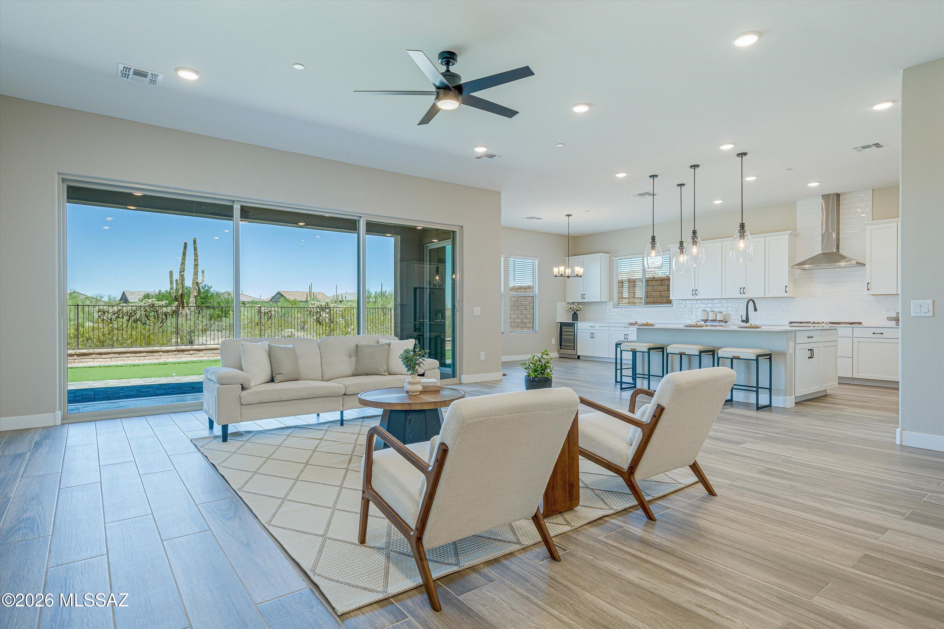 Experience luxury living without the wait! Welcome to this exceptional brand new 2025 construction home in the prestigious gated community of Saguaro Reserve, where designer finishes, premium upgrades, and breathtaking mountain views come together in one stunning package.


Offering 4 bedrooms, 3 full bathrooms, and a spacious 3-car garage, this thoughtfully designed home features 12-foot ceilings and an impressive 16-foot multi-slide glass door that fills the home with natural light and seamlessly connects indoor and outdoor living.


The gourmet chef's kitchen is the heart of the home, showcasing premium Café appliances, a generous Butler's pantry, two built-in wine refrigerators, quartz countertops, abundant cabinetry, and an oversized island perfect for entertaining. Unlike waiting months for new construction, this home is truly move-in ready. The professionally designed upgrades have already been completed, including custom designer paint throughout and a beautifully finished backyard featuring professional landscaping, pavers, and a putting green. Everything is ready for you to enjoy from day one.

The private backyard offers no neighbors directly behind, creating a peaceful setting to relax while taking in the beautiful mountain views and Arizona sunsets.

Additional features include a tankless water heater, energy-efficient construction, and all the benefits of owning a brand-new home with none of the hassle of selecting upgrades or waiting for construction to be completed.

This is a rare opportunity to own a fully upgraded, move-in-ready luxury home in one of Tucson's most desirable gated communities in Dove Mountain. Experience the perfect blend of modern elegance, comfort, privacy, and convenience at Saguaro Reserve.