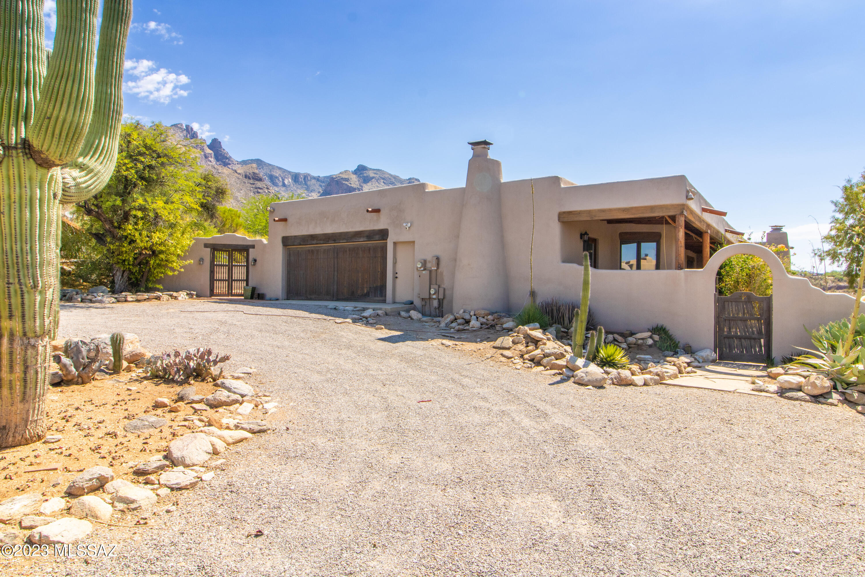 Dramatic mountain views by day-- Romantic twinkling city lights by night from this stunning Santa Fe home. Home has 4 bedrooms and 3 bathrooms. High ceilings with huge beams, 3 Beehive fireplaces. Beautiful granite kitchen countertops; built-in desk & wine rack. Front entry with winding brick walkway & raised planter beds. . Master Bedroom has a surprise balcony over the canyon under Finger Rock. Covered full length patio over city lights & private desert. Secluded driveway to front entry on this 1.05 acre lot. Close distance to La Encantada, art galleries, fine dining & shopping. Catalina Foothill School District.  Call today for a private viewing.** Home has solar,  Owner credits $200 a month toward electric bill **