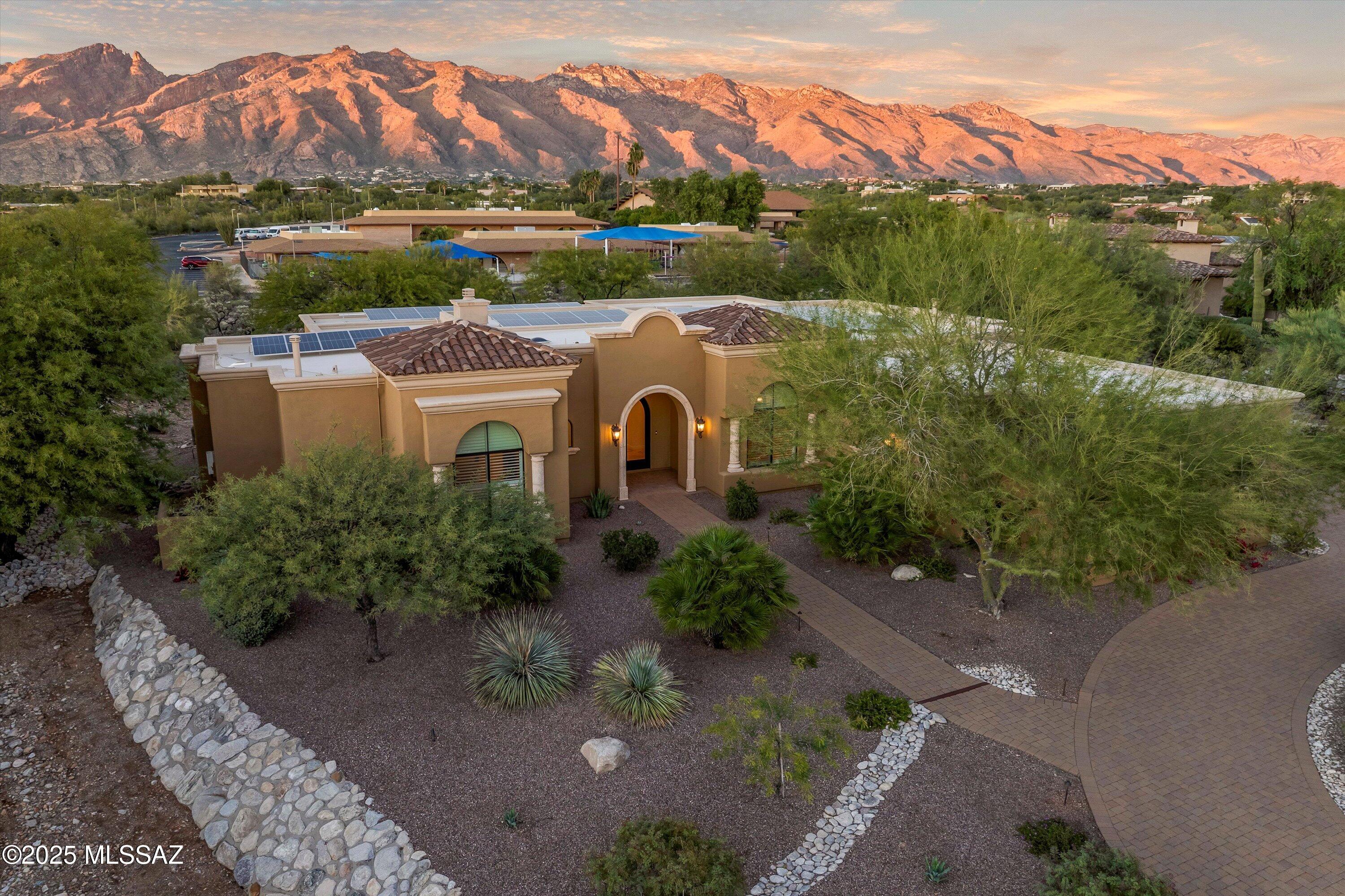 Experience refined elegance in this stunning Mediterranean contemporary home, located within the prestigious gated community of Villa Toscana in the Catalina Foothills. This beautifully designed single-story residence offers 3,450 sq. ft. of thoughtfully planned living space, featuring four bedrooms and three and a half baths.

A brick-paver driveway leads to a grand foyer that opens into an impressive great room highlighted by soaring ceilings, expansive windows, and a cozy fireplace. Designed for effortless entertaining, the space includes a wet bar with custom built-ins and a wine refrigerator. The gourmet kitchen is a chef's delight, showcasing alder cabinetry, granite countertops, a center island with breakfast bar, and premium Wolf and Sub-Zero appliances. The luxurious primary suite features a coved ceiling, a generous walk-in closet with custom built-ins, and a spa-inspired bath with dual vanities and a relaxing garden tub. Travertine flooring and oversized doors throughout the home enhance its sophisticated and timeless appeal.

Situated on a private .8-acre cul-de-sac lot with mountain views, the property offers an expansive wraparound rear porch and a walled yard with ample space for a future pool. Adding exceptional value, the home features an owned solar energy system, providing significant utility savings, increased energy efficiency, and long-term sustainability.

This exceptional home seamlessly blends luxury, comfort, and efficiency in a serene setting, just minutes from Foothills amenitiestruly a must-see for discerning buyers.