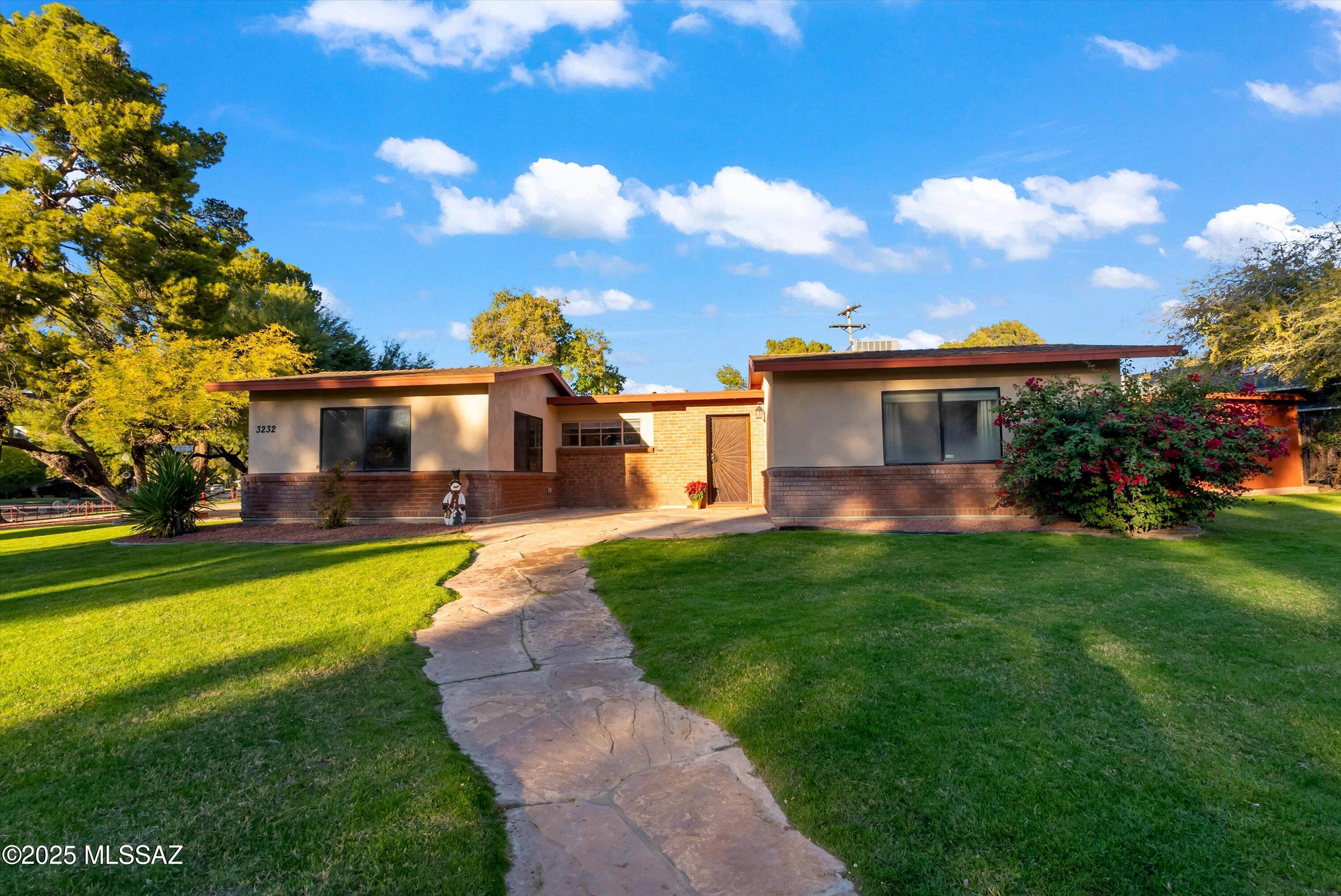NEW ROOF/HVAC! Welcome to historic Winterhaven, home to Tucson's festival of lights. Known for its family friendly community and tree lined streets that create a classic feel. This charming mid-century home sits on a premier corner lot along the newly paved bike path, centrally located minutes from the university. Move in ready featuring new interior/exterior paint, new stainless steel fridge, newer stainless steel range, dishwasher, and microwave. Enjoy the large backyard with large patio and cozy outdoor fireplace. Private tall block walls, custom gate/security doors, large lush lawns, garden area, mature fruit trees, and a shed/workshop. Includes 2 car garage, 3 large bedrooms, 2 water heaters, granite countertops, whole home surge protector, and security lighting/cameras.