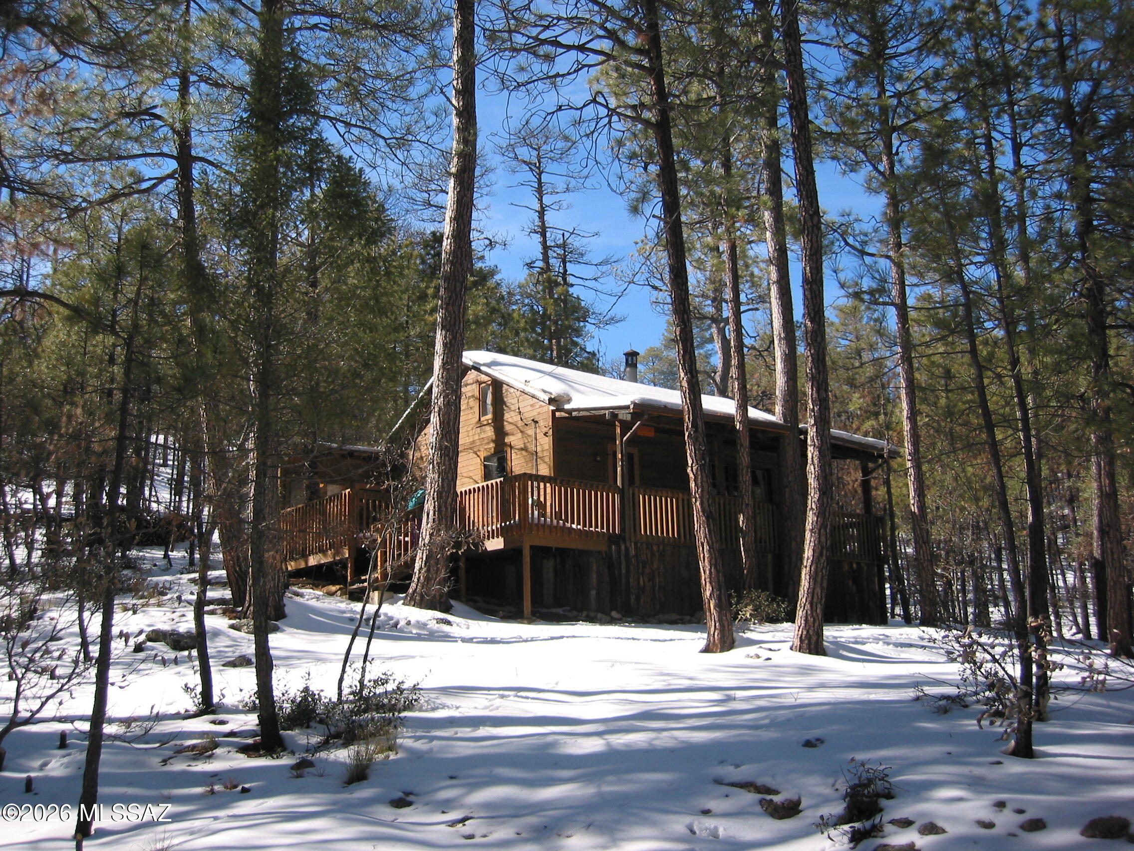 Enjoy 4 seasons in this rustic cabin nestled in an oak-pine forest. Only 1 hour from Tucson, at approximately 7,000 ft elevation, this recreational cabin offers a cool retreat on a secluded lot  that is far removed from the rush of urban life. A great room features a vaulted ceiling, sleeping loft and stone fireplace.  multiple large windows provide ample light and views of the forest from all sides.  Experience the rain from the covered front porch, watch the birds from the deck, explore the surrounding forest or just relax next to a cozy fire with a good book. The kitchen boasts a classic 1920's antique wood burning stove that has been converted to propane.