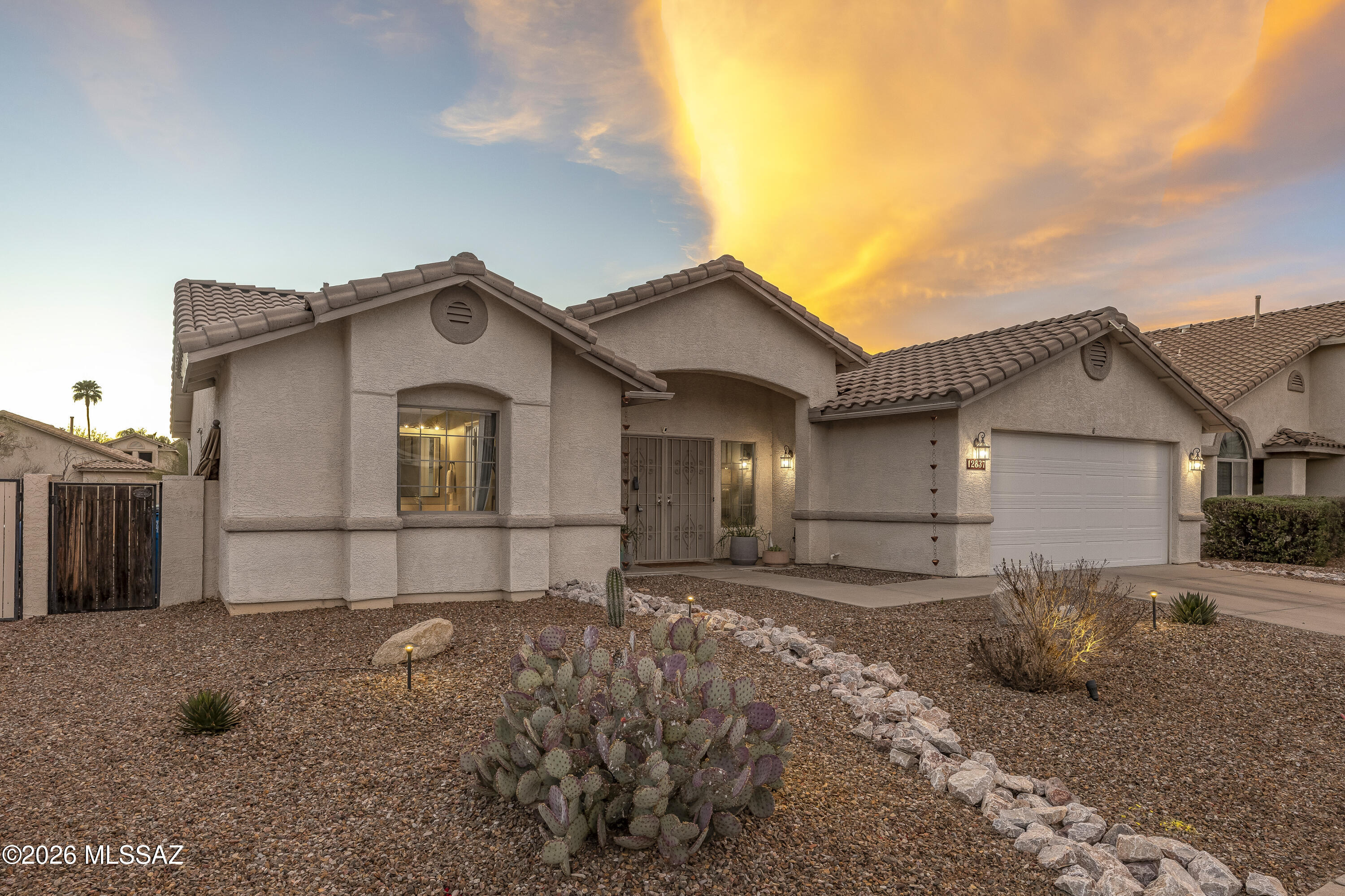 This lovely 2021 sq. ft. home has a welcoming updated interior with neutral paint palette. The 3 BR/2 BA home features a Family Room, Dining Room, and Living Room with real wood floors and an updated tile fireplace. Updated Kitchen Cabinets and Granite Countertops. Stainless Appliances (GE Microwave, and Whirlpool Stove and Dishwasher) and LG Stacked Washer/Dryer all convey. Windows are Dual Pane and have Solar Energy Star Screens. Front Door includes a Metal Security Door. Pentair/Pentek Whole House Water Filtration System. Master has Walk-in Closet, Soaking Tub, Double Sinks, and Separate Shower/Toilet Room. NEW 2025: Microwave and Cabinets Updated  NEW 2024: Garage Door NEW 2023:  Kitchen Stainless Appliances. NEW 2023: LG Washer & Dryer, Back Yard Pavers, Artificial Turf, and Interio Paint  NEW 2021: Hunter Douglas Ceiling Fans. UNIQUE FEATURES: This home has a beautiful, maintenance free yard with covered patio, pavers, and artificial turf. The garage is extended size for large/long vehicles and has a newer garage door with Lift Master Remote. This home is located at the foothills of the Santa Catalina Mountain Range. Hurry and don't miss out on this great home!