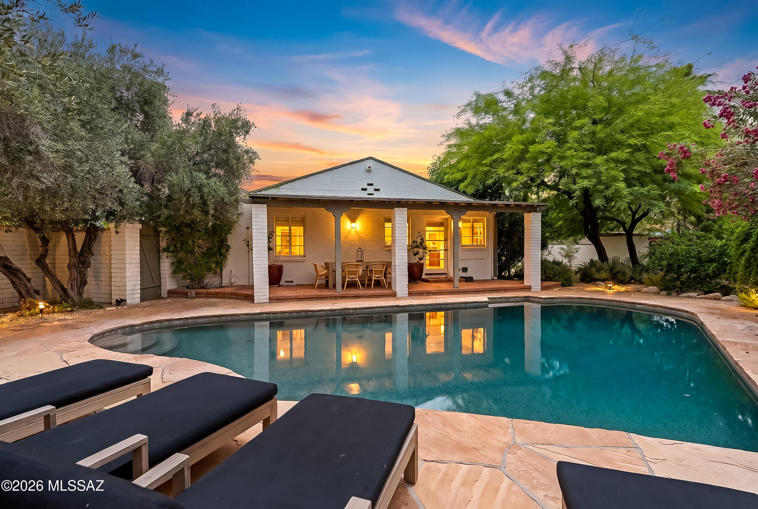 A rare and exceptional property in the historic neighborhood of San Clemente that has been thoughtfully restored with preservation in mind, this authentic ranch revival home easily blends character and function, and is perfectly sited and maintained to promote privacy among its beautiful surroundings. Every room and yard space has been thoughtfully curated and feels like a retreat. From the circular driveway with its curved brick walls and mature trees, to the backyard oasis with lovely covered brick patio, refreshing pool, and Mediterranean garden featuring mature olives, lemon, lime, mandarin, pomegranate, bougainvillea, lavender, and rose, this home invites comfort in a tranquil setting. Highlights include a split bedroom floor plan, open concept kitchen, hardwood flooring...Continued.. Roman clay finish walls & limewash paint accent walls, Zellige tile, primary bath with dolomite vanity counters, cast iron tub, and lovely courtyard off of the primary bedroom that lets in the natural light.  A most special property that exudes charm and embodies classic desert living, all in a convenient central location. San Clemente is recognized on the National Historic Register Districts and this home is a contributing property.