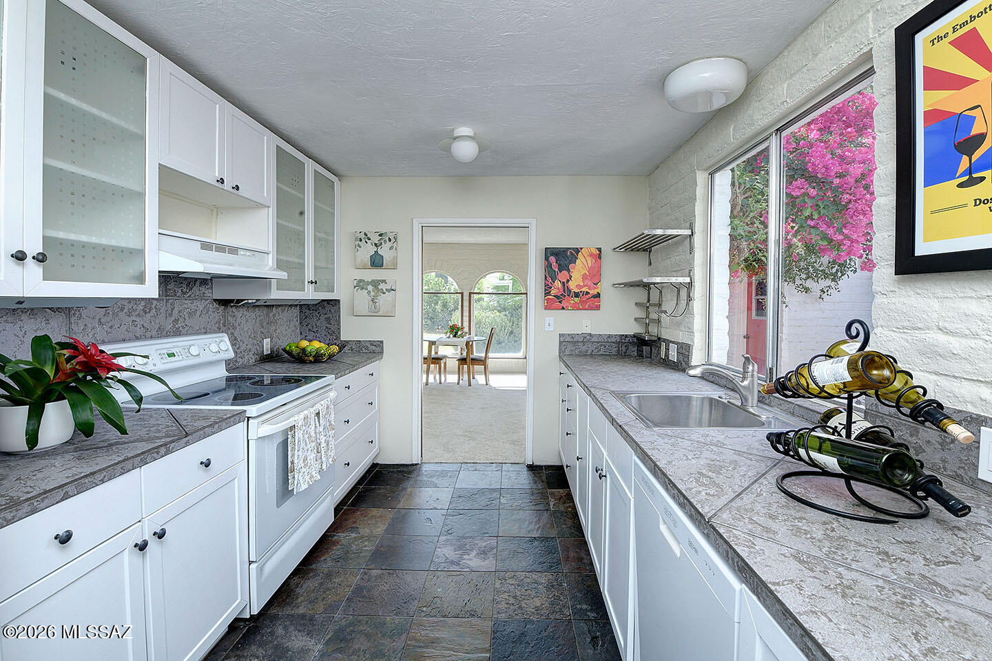 ADORABLE & SUPER CHARMING 2 BR/ 2 BA MASONRY BUILT CONDO IN THE DESIRABLE CASITAS DE CASTILIAN, AN OVER 55 HISTORICALLY DESIGNATED COMMUNITY DESIGNED BY RENOWNED ARCHITECT BENNIE GONZALES, IN CONVENIENT ORACLE/ROLLER COASTER AREA! HOME BOASTS FRONT & BACK BRICK PATIOS, SLATE FLOORING, UNIQUE DOUBLE ARCHED VIEW WINDOWS IN LIVING ROOM, COZY GAS BEEHIVE FIREPLACE, FRESH PAINT, NEW CARPET, BEAUTIFULLY UPDATED KITCHEN, DUAL PANE GLASS SLIDING DOORS PLUS A PRIVATE BACK YARD W/ COLORFUL PLANTINGS & AN AUTOMATIC SHADE AWNING! THE CASITAS SIT ON 17 LUSH ACRES OF COMMON AREA W/ TWO POOLS (ONE HEATED YEARROUND), TENNIS & A CLUBHOUSE OFFERING ACTIVITIES. HOA FEE COVERS WATER, GARBAGE PICK-UP, SEWER, BLANKET INSURANCE PLUS MAINTENANCE OF BLDGS & GROUNDS. A FABULOUS PLACE TO LIVE!