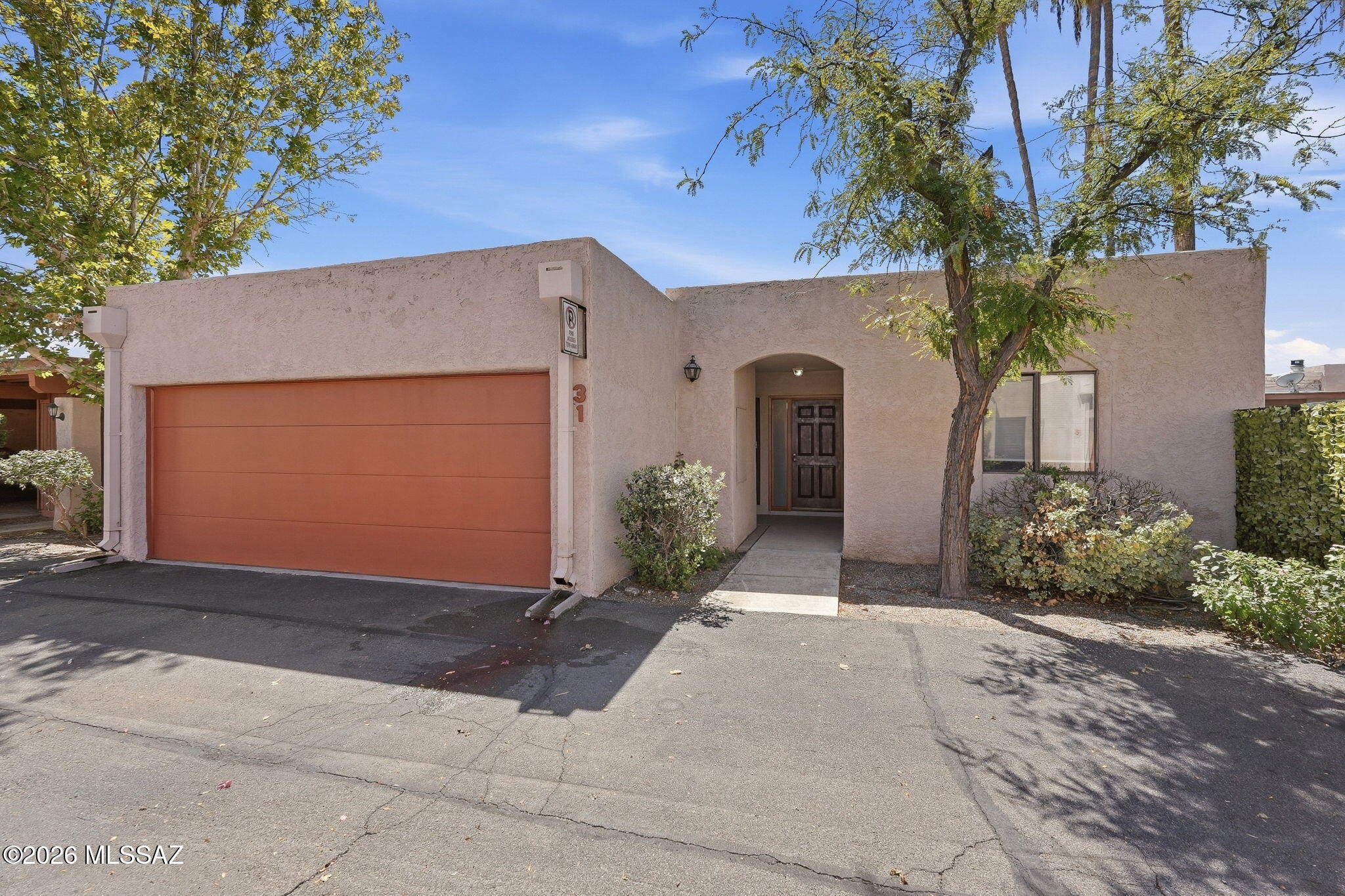 Tucked into the quiet heart of Linden Place Condominiums on Swan Road, just south of Grant, minutes from everywhere in Tucson. This 2BR/2BA gem is move-in ready or rental-ready. Park in your private 2-car garage and step through a formal entry into a bright kitchen with abundant counters and cabinetry, double sink, dishwasher, electric cooktop/oven, and a newer stainless fridge. A cozy breakfast nook overlooks it all. The spacious living area flows from a formal dining space to a living room warmed by a classic beehive fireplace, perfect for Tucson's winter nights. Large sliding doors open to your covered private patio. Full-size washer/dryer included. Plus a versatile guest room or home office. Peaceful, central, turnkey. Come look and make it your home today