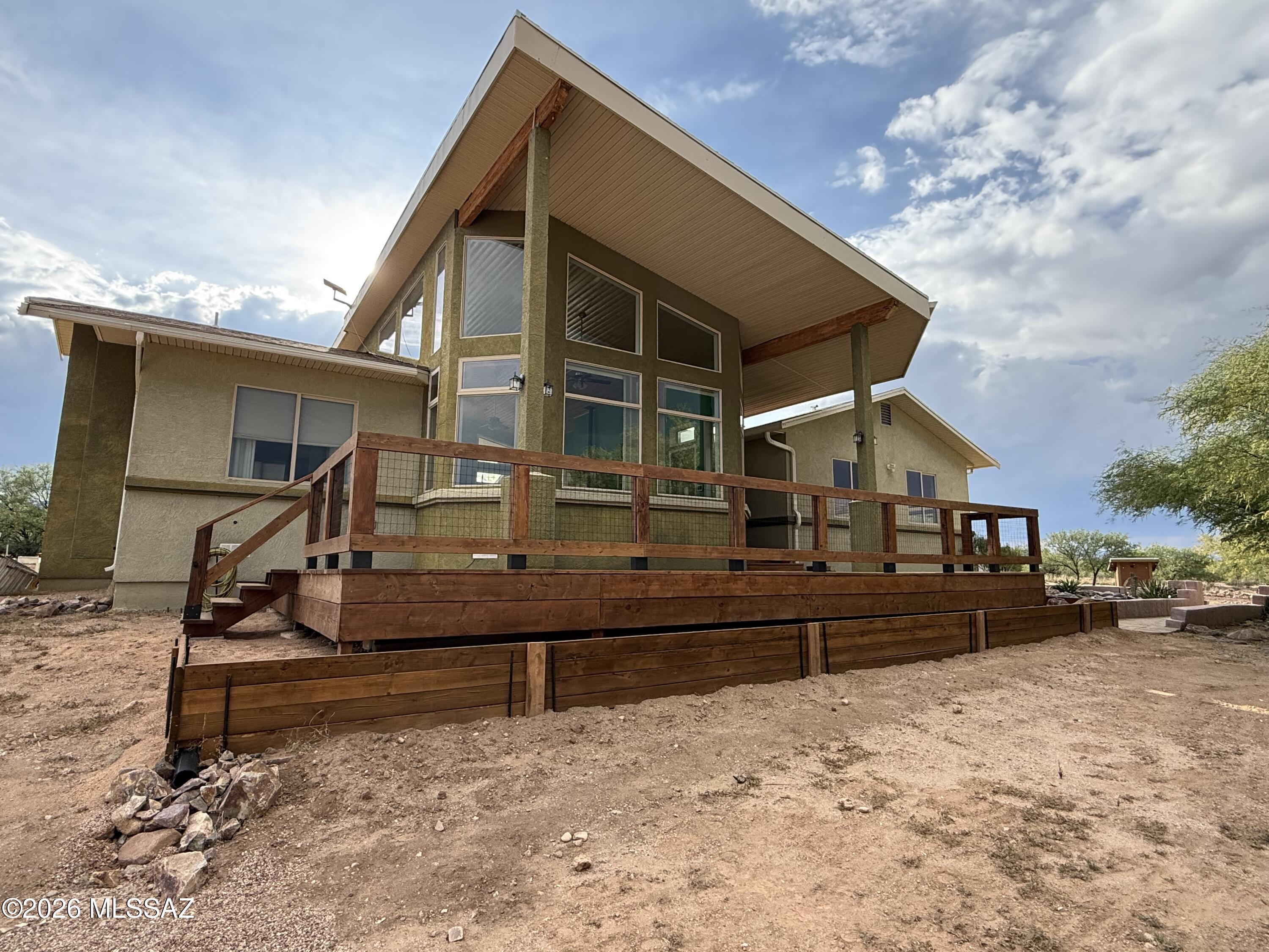 You will absolutely love this custom home that sits high above the valley below. There are beautiful views of the Dragoon Mtns that you will never tire of from the living room, front deck and bedroom 2. The floor plan is perfect for entertaining with an open great room and a kitchen and dining area that take in the views, decks and the fireplace. The knotty
pine ceilings are gorgeous! The kitchen boasts a large island, newer appliances and tons of counter and storage space. The light is amazing. Step into the master suite for a perfect way to end your day! It has a western view, 2 walk in closets, a lovely master bath with 2 sinks, jetted tub and separate walk in shower. Skylights bring in natural light as well.  This sale also includes parcel # 124-25-011R  on the corner of Homestead. The additional 4 acres has a hookup for the community water system and a pad cleared.