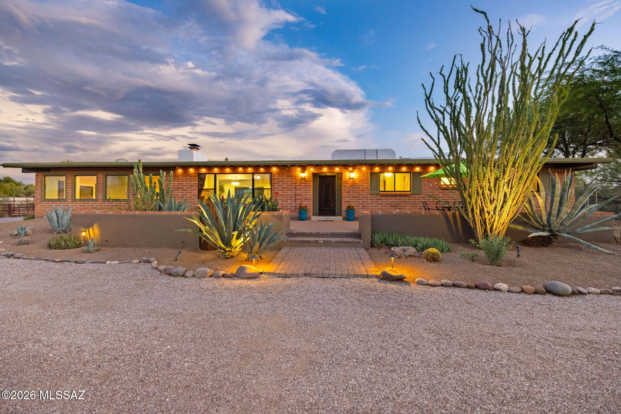 Welcome home to this comfortable, elegant 2535 sq ft. classic burnt adobe residence with new kitchen including huge granite island & new appliances. Polished concrete floors, remodeled bathrooms, large living room with outstanding mountain views, fireplace, sandstone hearth, separate family room/game room, huge laundry room/pantry with tons of storage & wash sink. Relax on the huge front patio with amazing views! Also enjoy the resort-like private back yard perfect for entertaining with newer pebble-tec plaster pool with gas & solar heat, separate spa, BBQ, fireplace, outdoor concrete table/seating. Landscape lighting & auto irrigation throughout. Newer 50 gallon water heater, ceiling fans in each room, solid wood interior doors, new dual pane doors & windows, 1.5 acre fully fenced lot Block wall frontage with electronic gate entrance, rusted metal elements throughout, recently coated roof, newer air conditioning and furnace, 4 stall mare motel barn with 4 12x24 stalls with water and electric and gutters  and ¼ acre turn out with excellent trailer accessibility and tack room, 2 car masonry garage with newer roof has compressed air, evaporative cooling, newer roof & compressor/storage room, 2 dog runs, 2500g rain recapture system with gutters, TONS of parking and privacy, RV parking with 50 amp/110 electric, water and sewer, 3 large storage sheds with newer roofs, paved city streets, paved car parking pad. Home includes alarm system, circular driveway, walking distance to ACE hardware, shopping at Broadway/Harrison, and unforgettable mountain views.