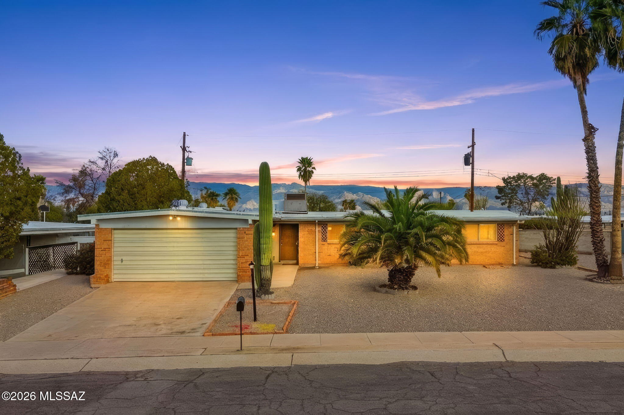 Classic 1963 Mid-Century Ranch with INCREDIBLE Mountain Views from INSIDE. + Garage + Swimming Pool + This 4-bedroom, 2-bath mid-century modern ranch offers 1,687 square feet of authentic Tucson character, single-level living, and timeless design in one of the east side's established neighborhoods.
Beautiful mature desert landscaping frames the property, creating instant curb appeal and a private, welcoming setting. Inside, exposed wood beams ties the Family Room, Kitchen, Mountain Views and Fireplace together. The dual sided fireplace is architectural centerpiece of the home. The floorplan provides generous, light-filled living spaces with a natural flow between the living, dining, kitchen, and family areas.  Sliding glass doors open to a backyard designed for true icon desert living. Enjoy a conventional swimming pool surrounded by thoughtful landscaping and open mountain views -- the perfect backdrop for entertaining or relaxing under Arizona sunsets.

Mid-century architecture. Pool living. Mountain views. Beautifully landscaped grounds. A true Tucson classic that balances character, comfort, and outdoor lifestyle.
