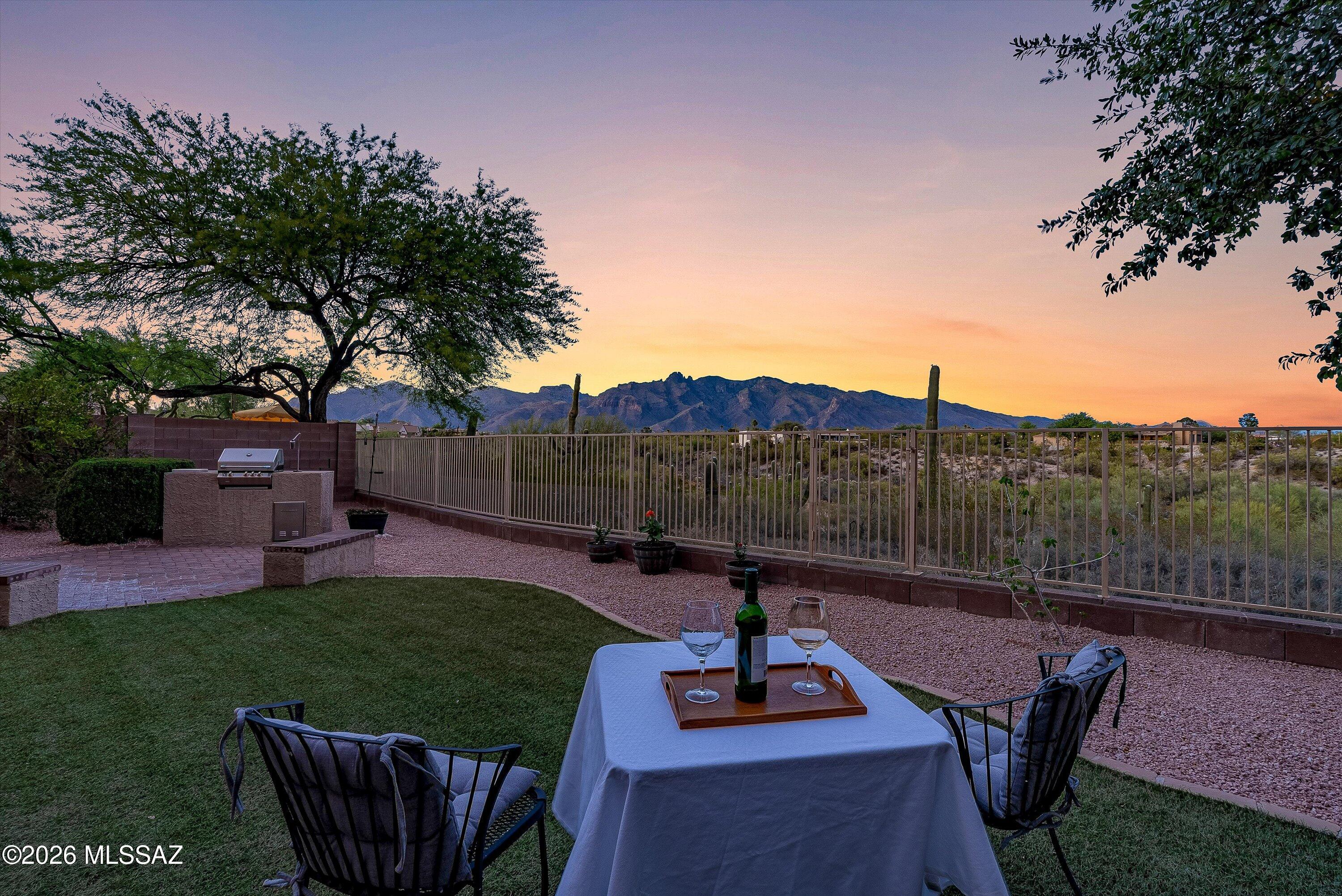 Nestled in a gated community and only 10 minutes from the University of Arizona.  This home offers stunning mountain views, exceptional privacy, and a serene backdrop of a lush greenbelt and mature landscaping. The backyard is designed for both relaxation and entertaining, featuring a brick patio with a, built-in BBQ, along with mature fruit and shade trees. A private gate opens directly to the desert, creating your own peaceful retreat just steps from home.  This inviting home offers 3 bedrooms plus a den and 2.5 bathrooms, combining comfort, charm, and a unique connection to the natural surroundings--perfect for enjoying the beauty and tranquility of desert living.