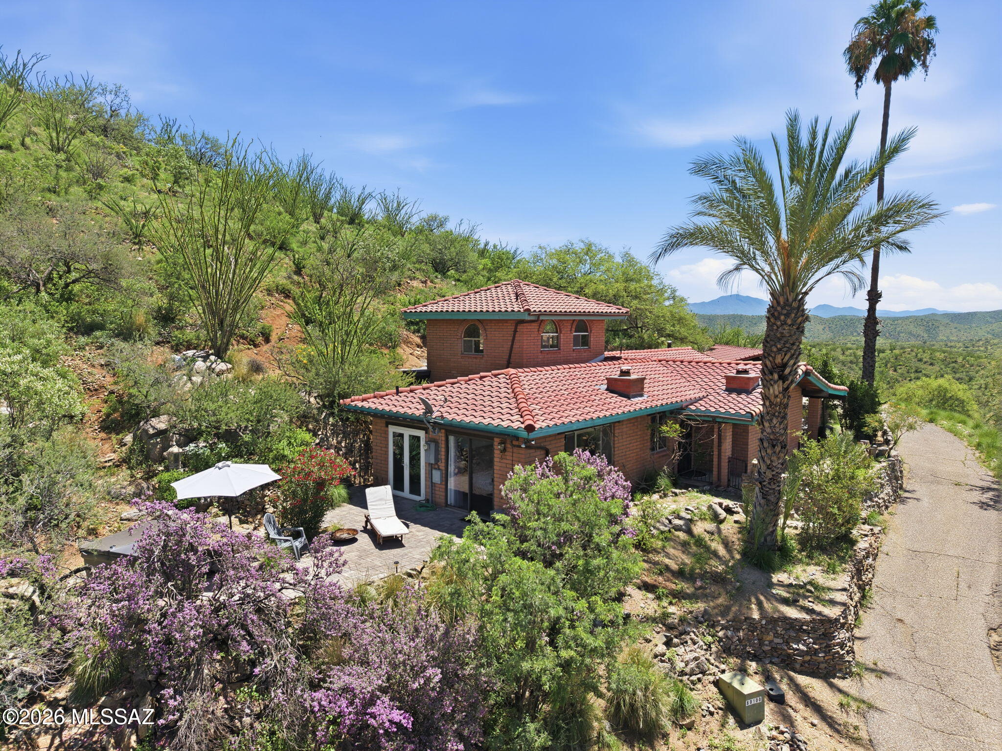 An Oasis in the desert !! This nice and cozy ranch style home is located in one of the most desirable and private areas in Santa Cruz County !! This truly exquisite, custom built home in Vista del Cielo is nestled on 5.34 lush acres with beautiful breathtaking views of the mountains, valleys, and skies !!   It is a birder's paradise !!  The arch shaped windows, doors and spa totally compliment the views of the natural vegetation and abundance of fruit trees.... Upstairs boasts a magnificent art studio, in addition to separate quarters outside used as a private work out room.  There was a bird symphony of over 16 different birds that were recently identified on the bird app Merlin !!!