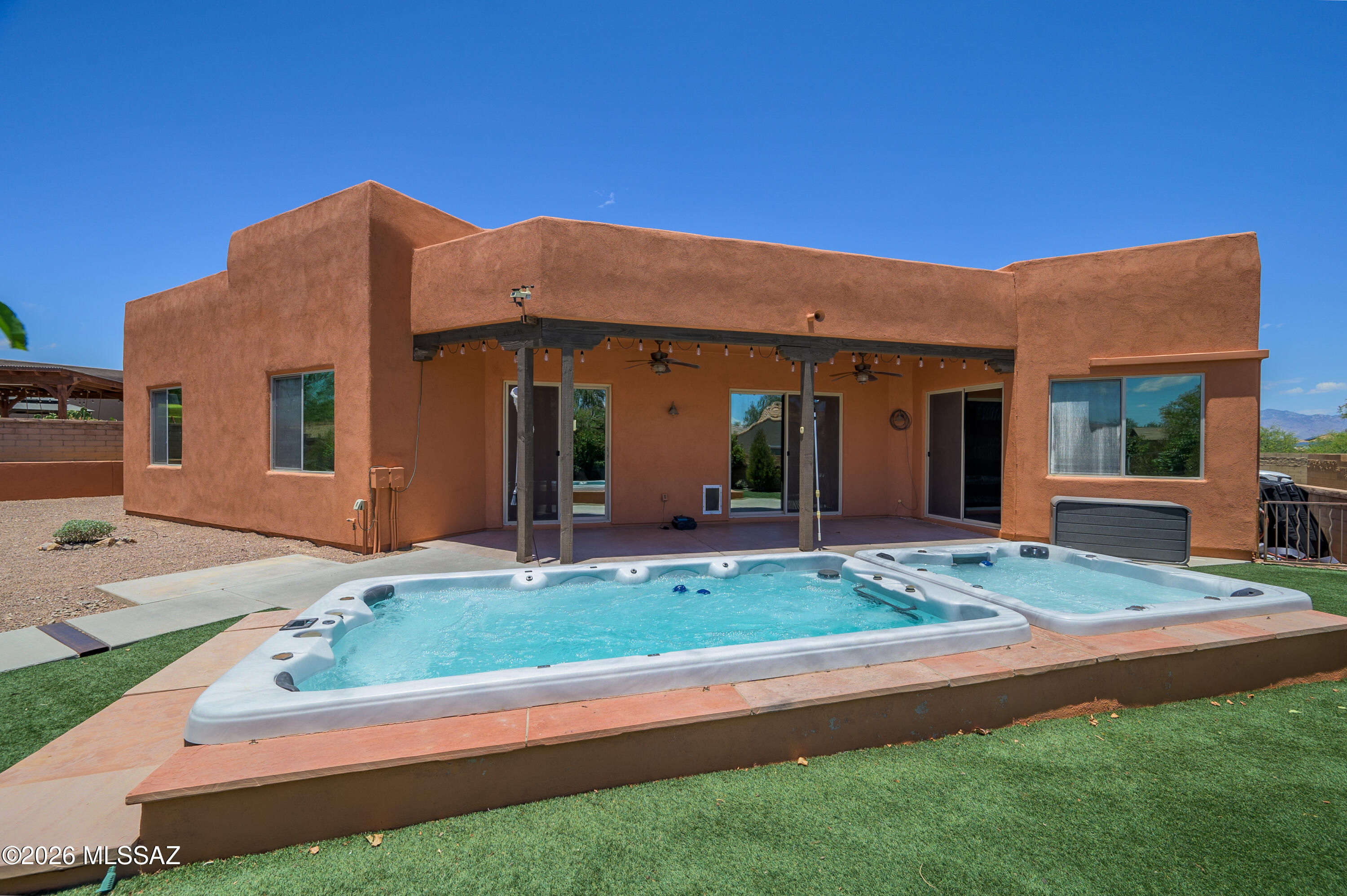 Welcome to the highly sought-after Civano subdivision on Tucson's Southeast side. This home is a rare gem within the community, as it is a premium lot featuring an extended driveway, no current neighbors behind, and an adjacent wash on the left. And this home has an attached GUEST QUARTERS with its own mini-split and a full bath!!

The home boasts a super-efficient solar system that generates 65 kilowatts of electricity daily, resulting in significantly reduced electric bills. And the best part: The solar panels are OWNED and PAID. The home also comes equipped with a bona fide top-of-the-line, best-you-can-buy 28 SEER HVAC system with 5-ton capacity and air filtration! The roof was recoated in 2025 as well. In 2021, an 8x8 HOT TUB and a 14' SWIM SPA were added. Whole-house water filtration with citrus filtration, tankless water heater, and a garage that's extended by 4' with 2 fans, built-in storage and a 50amp TESLA charger are just some of the other unique features. Yet there's so much more...

Inside, you have enhanced concrete flooring, 8" compared to your standard 4". The inside of the main home, guest quarters, and garage have been recently repainted. The kitchen has been updated with an attractive backsplash, decorative wood paneling has been added to the family room, and aromatic cedar has been installed in the primary walk-in closet. A mini-split system was installed in the primary bedroom to provide extra efficiency. The home is also equipped with all LED lighting, a stove vent with an automatic heat sensor, dual ovens, two closet pantries, cabinets for extra storage space in the laundry room, spray foam insulation for the garage, window tinting, and new exterior paint and wood staining as of 2025. Drip systems in front and back yards plus a garden bed has been added. Multiple fruit trees to enjoy providing shade, privacy, and delicious fruits, including limequat, lemon, pomelo and grapefruit. 

What makes this home even better is that it is located in one of the best subdivisions designed with principles of sustainability, such as goals for gas and water reduction, recycling, reduced automobile use, and affordability. They even have a K-5 and Middle School that is part of the Vail school district. There are tons of amenities, including two pools and spas, a huge recreation center, myriad walking paths, tennis, pickleball, soccer, a large community park, community garden, and so much more. Not only that, the home is minutes away from Saguaro National East with a slew of great hiking trails. Come see what practical and luxury desert living is like!! Make an appointment to see today!