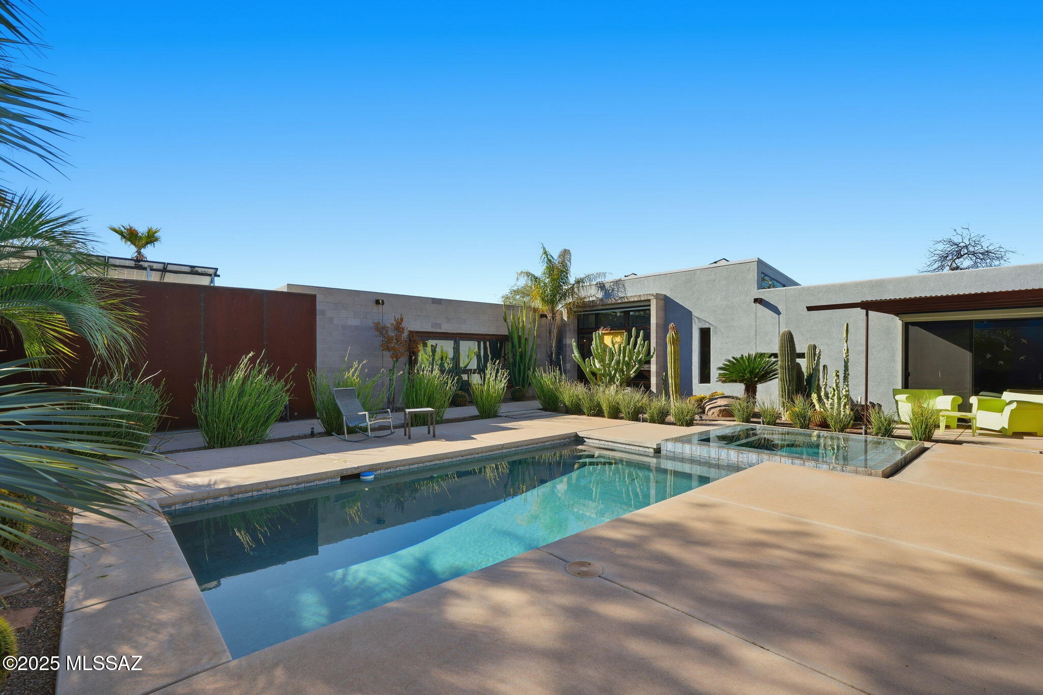Experience breathtaking modern living in this STRIKING CONTEMPORARY SHOWPIECE, where soaring ceilings, crisp architectural lines, and bold design make a lasting impression. An impressive oversized metal gate opens to a private courtyard oasis featuring a shimmering pool, zero-edge spa, and artful landscaping that elevates the serene, resort-style ambiance. Inside, expansive glass frames the dramatic courtyard backdrop, flooding the open living spaces with natural light. The sleek, chef-inspired kitchen showcases premium finishes and top-grade appliances, while spa-like baths highlight calming materials for rejuvenation. A thoughtful split floorplan creates ideal separation between living, guest, and primary retreats—an inspiring modern sanctuary.