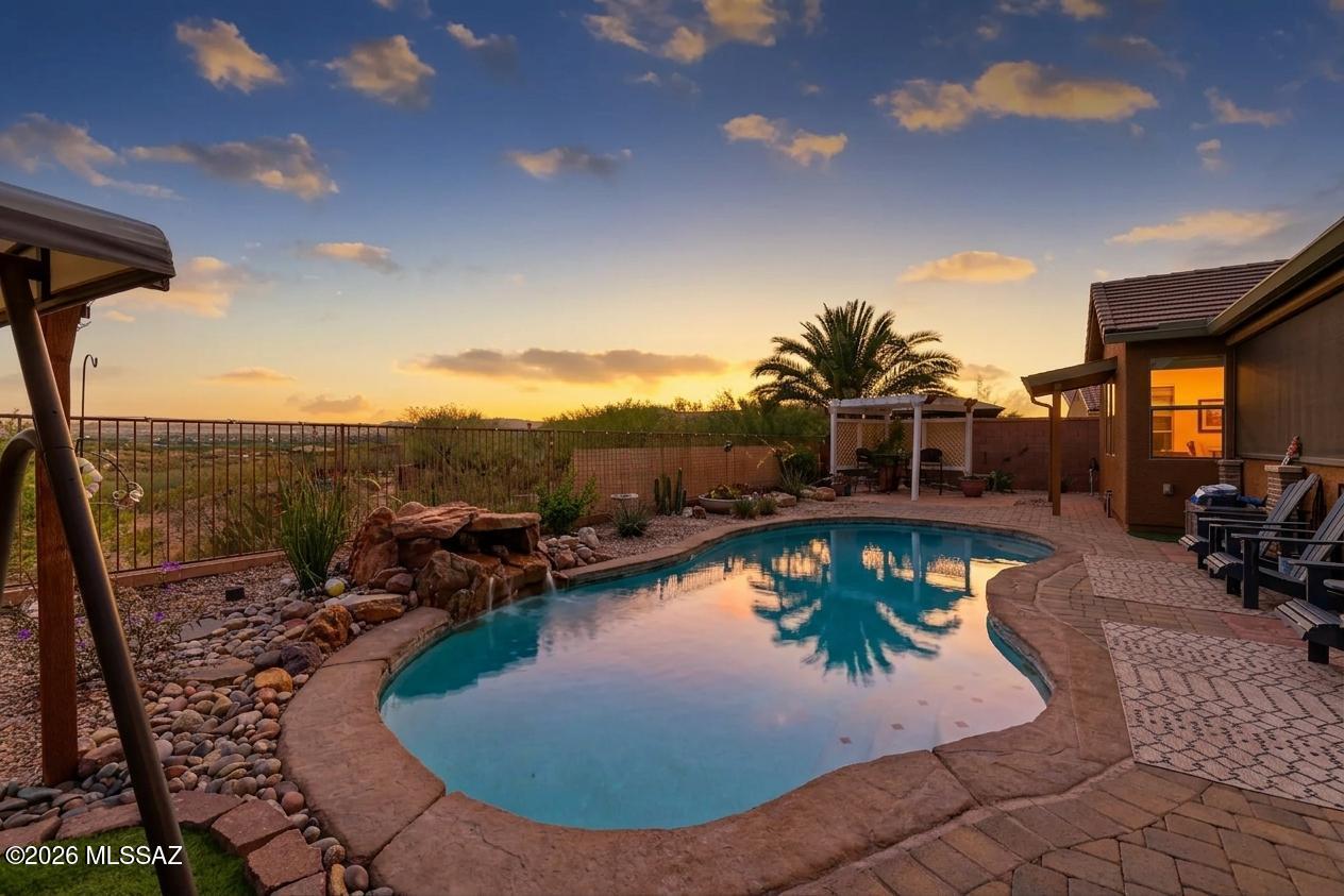 Amazing opportunity for updated 2,987 SqFt 3 bed/2.5 bath split floor plan with den and flex room, single story w/no stairs/no steps, 2009 built modern contemporary home on premium .22 acre elevated view lot featuring unobstructed panoramic Sonoran desert and Santa Rita mountain views, seller owned solar photovoltaic panels, heated pool, 633 SqFt attached 3 car finished garages located in the desirable gated community of Madera Highlands Encore. Featuring NE/SE orientation, mountain views, no neighbors in front or behind, modern flat concrete tile roof, concrete driveway, concrete sidewalks, freshly painted outside ($6500), on and off-street parking, landscaped manicured front yard w/crushed rock, Saguaro cactus, fruitless olive and palm trees, custom rustic garage doors, metal gutters, concrete walking path to secure gated enclosed front patio. Inside enjoy tall textured ceilings (no popcorn), energy efficient double pane windows, new custom matching blinds, solar window screens, luxury plank and tile flooring throughout (no carpet), built-in ceiling fire sprinkler suppression system, crisp white 8' internal doors, ADT alarm installed, zoned gas Trane HVAC system (new 2023 $27K),  dual digital Smart thermostats, Pex plumbing (no polybutene), plumbed whole home water filtration Green water softener & carbon filter system (new 2024 $3200), recessed lighting, luminated ceiling fans and formal dining area. Entertainer's dream open concept kitchen featuring full slab granite counter tops, matching massive full slab granite island with bar seating, self-closing designer staggered modern kitchen cabinets with lower cabinet pull-out shelves, stainless steel appliance package, convection oven, brick backsplash, butlers pantry with walk-in closet, laundry room with exhaust fan, washer and dryer included, adjacent to spacious great room with fantastic natural light, built-in 4 speaker surround sound and gas fireplace. Endless possibilities for the attached enclosed West facing tiled flex room, currently used as a home gym, with remote control outside electric powered shades. Large primary suite with full ensuite bathroom featuring dual walk-in closets, separate soaking tub, walk-in shower and matching dual executive height cultured marble modern vanities.
Attached 633 SqFt finished 3 car garage with remote controlled garage doors, concrete floors, provide ample room for workshop, toys, golf carts or convert a stall to home gym.
Epic Tucson sunsets await from your private backyard retreat with open wash and no neighbors behind, providing 180° unobstructed Santa Rita mountain views! Relax in your sparkling heated pool year-round, soothing waterfall, new electric pool heater ($3824 in 2023), cartridge pool filter, variable speed pool pump, raised flower beds, orange and lime trees, Tuff shed storage, Belgard brick pavers, plumbed for gas grills, ramada, side gates, view fencing surrounded by HOA approved raised privacy block walls. 
Affordable $117 monthly HOA includes secure gated entrance, community pool, basketball courts, tennis courts, grassy park, extensive paved walking paths, street and common area maintenance. Call to make your appointment to view this gorgeous move in ready home today!