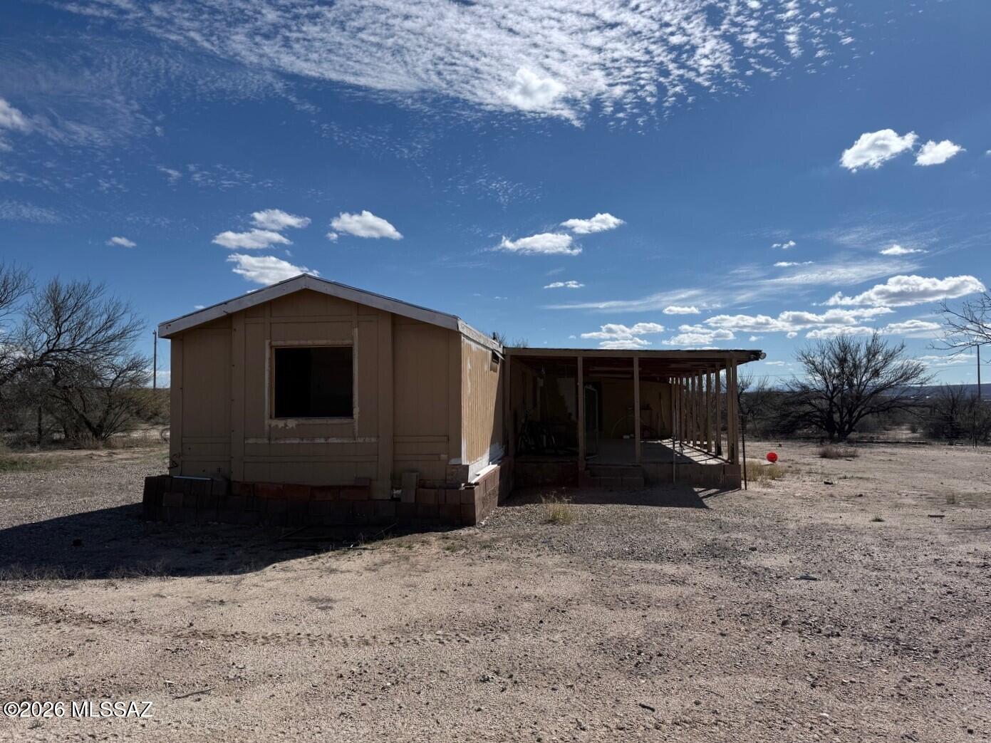 Explore the possibilities. Here is a Fixer Upper 3 bedroom 2 bathroom 980 square foot Manufactured Home built in 1988 located on 5 acres with amazing views waiting for someone to restore and make their own. Plenty of room for horses and close to State Land to roam for miles. There is a water storage tank already in place that needs to be hooked up. Previous occupants were hauling water but there may be a well share available. Buyer to do their due diligence as the current owner has little knowledge of the property including availability of water. This private parcel is only a 10 minute drive to I-10 or Downtown Benson for all the conveniences of town. The owner of the property is an out of town licensed Real Estate Agent in the State of AZ.