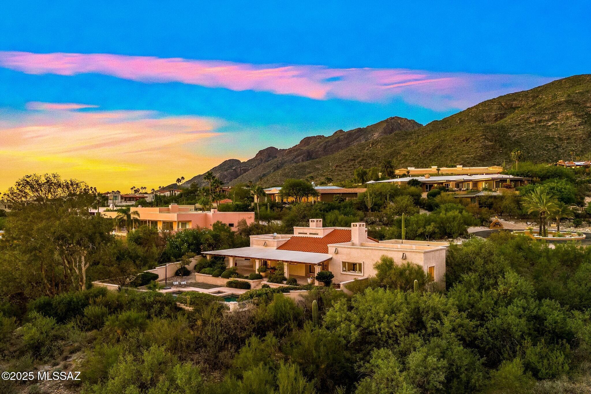 Nestled in the heart of the foothills of the Santa Catalina Mountains, this prestigious gated community rises above the city's twinkling lights and wraps around breathtaking panoramic vistas. Perched on a sprawling private lot, this exceptional home offers endless views of Tucson's sparkling cityscape and majestic mountain backdrop.
A sparkling pool and spa set the stage for year-round outdoor enjoyment, while the wood-beamed covered patio invites relaxation and entertaining amid desert serenity.
Inside, expansive windows fill every room with natural light, framing captivating views in every direction. Multiple living spaces provide comfort and flexibility for everyday living or gatherings. The open kitchen is a delight, featuring granite counters, a five-burner gas cooktop, stainless steel appliances, a casual breakfast nook, and picture-perfect views from the kitchen sink. The living room impresses with soaring ceilings and stunning Catalina Mountain views.
The primary suite is a peaceful retreat designed to showcase the beauty of its surroundings. Enjoy generous space, a walk-in cedar-lined closet with built-ins, and a beautifully appointed en suite bath featuring dual vanities, a garden tub, and a spacious walk-in shower. Step directly from the suite onto the deep covered patio to unwind in complete privacy while soaking in the mountain and city views.
A seamless drive down Campbell Avenue connects you to Tucson's finest dining, shopping, and cultural destinations yet when you return home, you'll feel worlds away. This is where timeless elegance meets the magic of desert living in one of Tucson's most coveted neighborhoods.