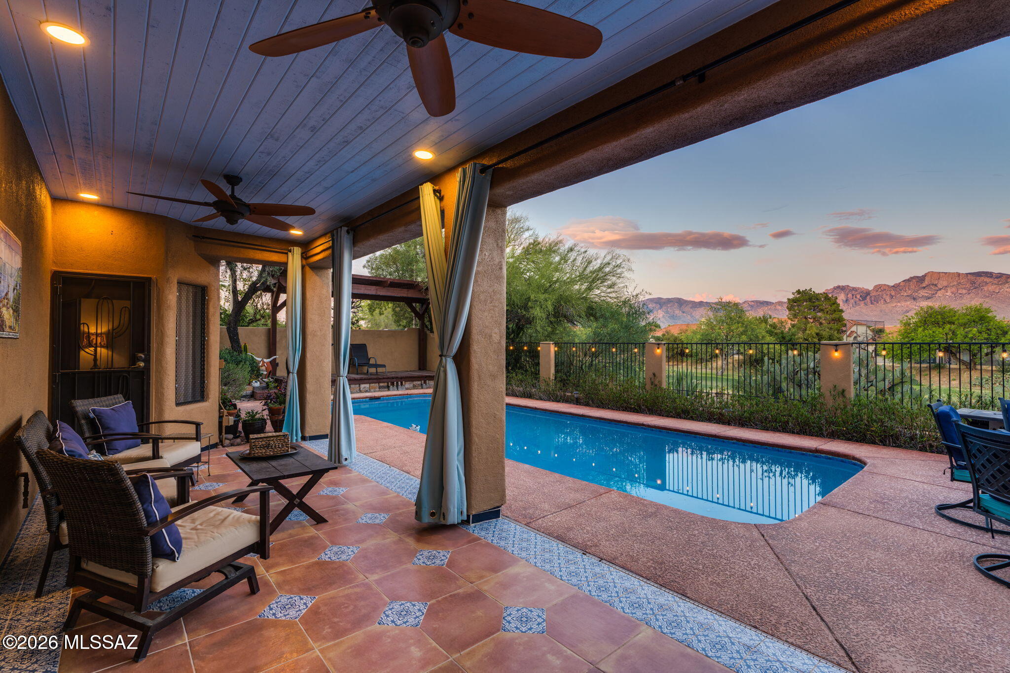 Offering the perfect blend of luxury, comfort and amazing views, this Santa Fe style home is tucked away in sought after Canada Hills in Oro Valley. With east-facing backyard, it provides unobstructed views of  natural desert, the 10th Fairway of the Conquistador Golf Course, and the picturesque Catalina mountains with its ever-changing sunrise and sunset skies. The home features 2 primary suites (one on each level) and 3 additional bedrooms, and 3 1/2 bathrooms.  Step inside to discover 18'' Travertine tile flooring in public areas and wood in the bedrooms (NO CARPET), 14' ceilings in the first-floor public areas, 5 ceiling fans, large windows, oversized 10' x 8' sliding glass door in the family room, and lighted niches and built-in bookcases in the living/dining area. The chef's kitchen is truly the heart of the home, showcasing granite slab countertops, large (approx 6'x 8') island w/bar seating as well stainless appliances (inc jenn-aire 5-burner/grill cooktop), french door refrigerator & spacious closet pantry. This is the perfect space for both daily living and entertaining. The kitchen flows seamlessly into the view-capturing breakfast nook and opens to the bright great room  w/cozy corner fireplace, and 14' ceiling creating an inviting space for gatherings both large and small.  Designed with flexibility in mind, this home is perfect for multi-generational living or guest quarters as it features two large primary bedroom suites, one on each level, with walk-in closets, en-suite baths, and private access to either a covered patio or an East-facing balcony. This flexible design makes the home a great candidate for those considering ADA modifications on the main level. The RESORT-STYLE BACKYARD IS WHERE THIS HOME TRULY SHINES. Relax by the Pool , or additionally enjoy the desert, unobstructed Golf Course and Mountain Views from the Covered Patio or the Pergola. Lush easy-care Desert Landscaping, bubbling ceramic fountain and prolific lemon tree add to the outdoor enjoyment. This spacious two-story gem is packed with upgrades and recent enhancements. Both HVAC units were replaced in 2023.The entire roof was redone in 2025 and the Exterior of the home was resurfaced with new stucco, painted and sealed in 2025. Additional upgrades/enhancement are found in the Documents tab. Ideally located near popular Oro Valley schools, shopping, dining, medical facilities, Conquistador Golf Course & Oro Valley Community & Recreation Center with fitness center, swimming pools, racquetball, pickleball & tennis courts. This lovingly maintained and upgraded home is designed for those who appreciate refined living & effortless entertaining. It is more than a home, it's a lifestyle!