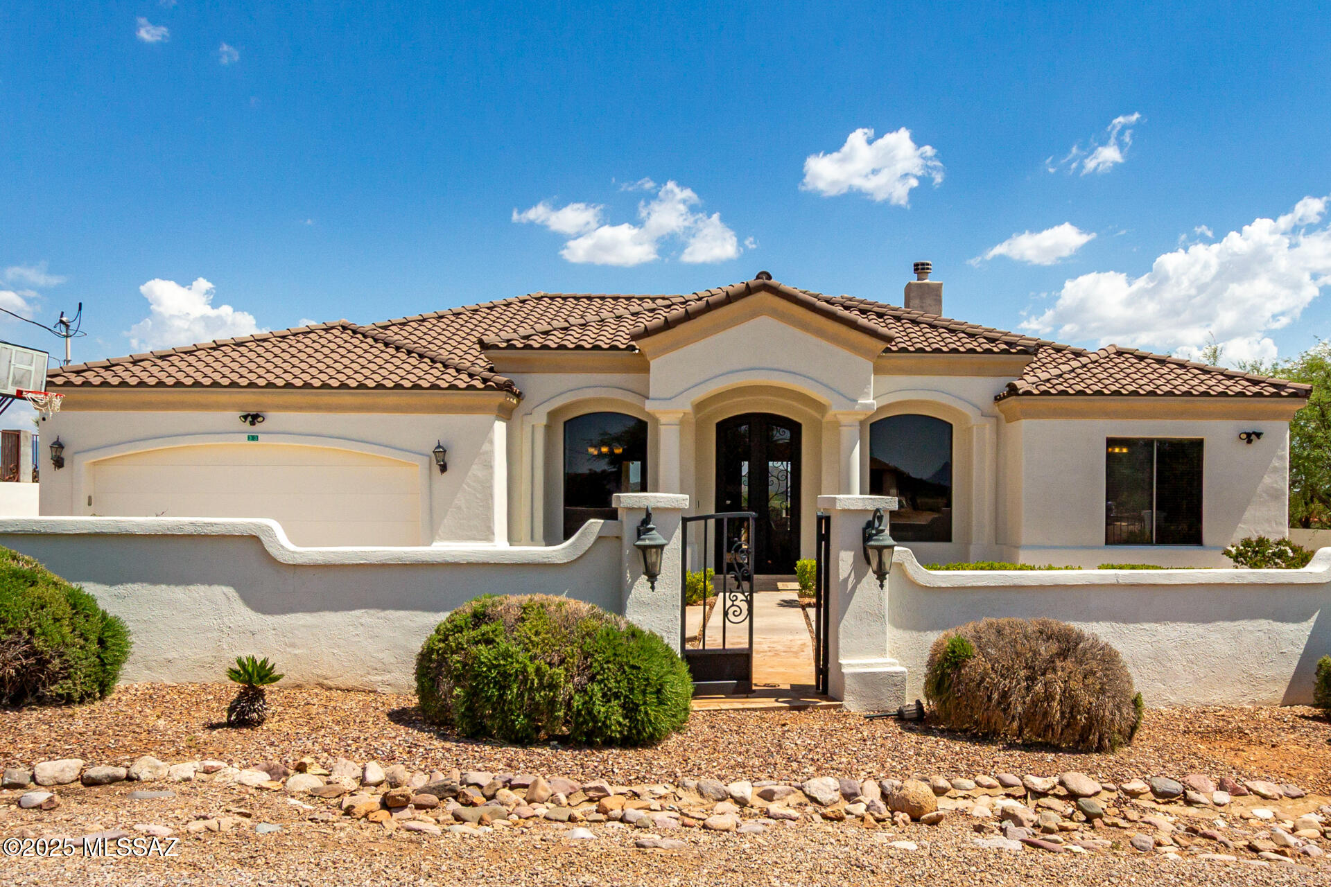 Welcome to this beautifully maintained custom-built home in the sought-after Rio Rico Estates. Built in 2004, this 2,344 sq ft residence sits on an expansive 0.85-acre lot with stunning mountain views. Offering 4 bedrooms and 4 bathrooms, including a Jack-and-Jill setup for two of the bedrooms, this home is thoughtfully designed for both comfort and functionality. Step inside to an inviting foyer with abundant natural light, tall vaulted ceilings, and a tasteful blend of tile and carpet flooring. The spacious living room, formal dining area, and impressive great room with a cozy fireplace create the perfect setting for everyday living or grand entertaining. The spotless kitchen features stainless steel appliances, granite countertops, crown-moulded cabinetry, a two-tier breakfast bar, a breakfast nook, a gas range, and a wine cooler. The serene primary suite offers a sunny bay window sitting area, a luxurious ensuite with a makeup desk, soaking tub, and walk-in closet. Exterior highlights include a 2-car garage, circular driveway, double gate, full perimeter wall, and a covered patio. There's ample room to build both a guest house and a swimming pool, giving you flexibility for future expansion. Conveniently located with access from Exit 12 and Exit 17, this property is close to San Cayetano Elementary School, a local gym, and nearby walking trailsoffering the perfect blend of privacy, convenience, and Arizona living.