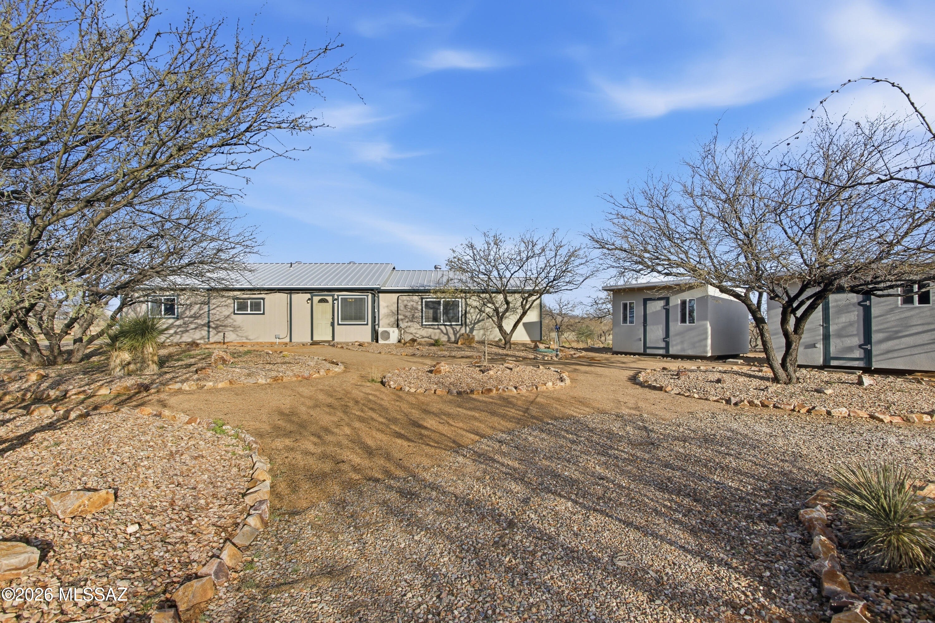 Bungalow-style gem on 5.55 fully fenced acres with stunning mountain views in every direction! This one-year-old home features a spacious great room, dual-pane windows, ceiling fans, and a relaxing covered porch. Most buildings have upgraded metal roofs, and the carport is reinforced for solar. Enjoy an orchard, privacy gate, dugout ponds, and irrigation throughout. A pad is ready to pour for a greenhouse, workshop, or expanded carport. Includes a 12x10 storage shed and plenty of space to park an RV or build a second home. USDA Loan Eligible Property! A truly special desert retreat off paved Dragoon Road!Seller may be open to considering buyer concessions with an acceptable offer.