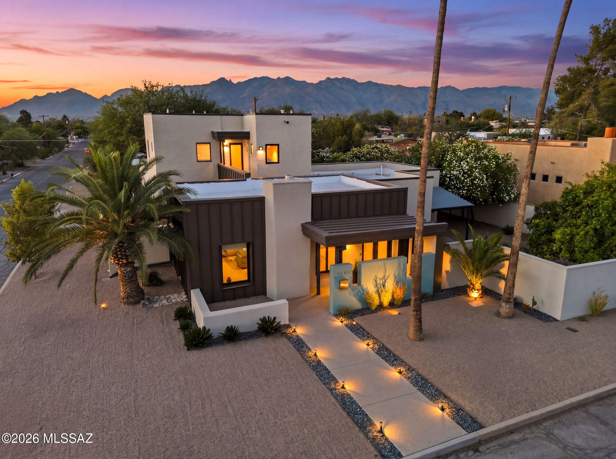 Nestled in Tucson's coveted Historic New Deal Acres neighborhood, this exceptional estate offers a rare blend of architectural sophistication, privacy, and convenience just minutes from the University of Arizona, Banner - University Medical Center Tucson, and Tucson Medical Center. Extensively reimagined with an elevated modern aesthetic, the residence showcases seamless indoor-outdoor living with four private patios, a custom outdoor kitchen, and a striking fireplace designed for year-round entertaining. Situated on a lush 0.28-acre home site in the heart of Central Tucson, the grounds create a private oasis featuring an expansive lawn, mature landscaping, water-harvesting cisterns, and a thriving citrus orchard.  Inside, refined finishes abound, including ROGO polished concrete floors complemented by bias-cut bamboo and marble flooring, designer LED lighting, custom mirrors, and premium Shade Store window treatments. The chef's kitchen is appointed with quartz countertops, a Brizo faucet, Wolf double-oven gas range with hood, Sub-Zero refrigerator, and Thermador dishwasher. The luxurious primary and guest baths feature Hansgrohe fixtures, while flexible living spaces include three bedrooms, 2.5 baths, a loft, and a 105-square-foot climate-controlled studio ideal for a private office, creative workspace, fitness room, or retreat. An extended-length two-car garage offers epoxy flooring, custom cabinetry, and abundant storage. A rare opportunity to own a meticulously curated luxury retreat in one of Tucson's most established and centrally located neighborhoods.