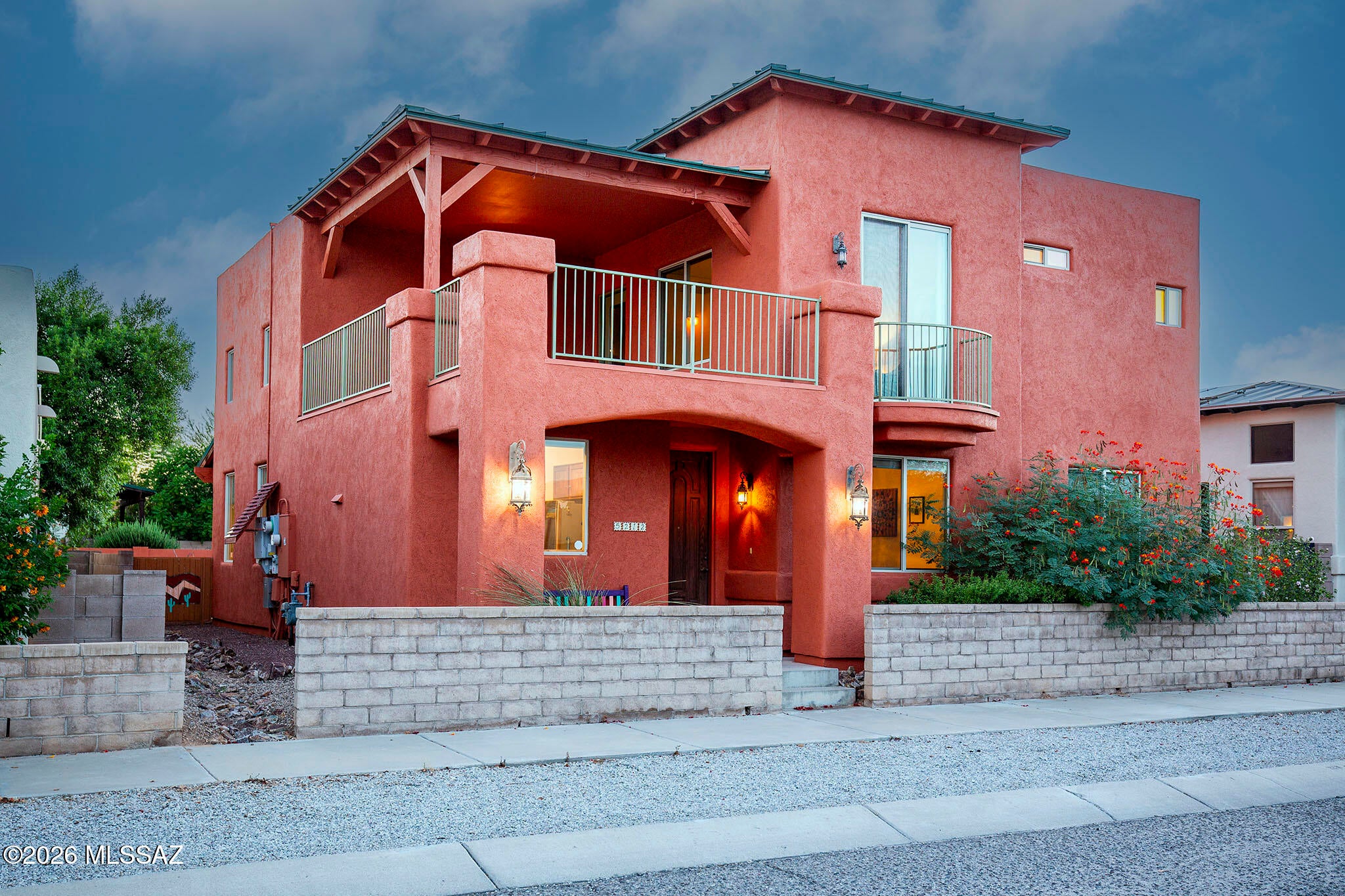 Mountain views, distinctive architecture and owned solar are just a few highlights. Step inside and let your eyes follow the light upward to the stained glass windows framing the living room. This distinctive home sits in the eastern edge of Civano, just steps from the community garden and park, unobstructed Catalina and Rincon Mountain views. Three bedrooms provide flexibility, including one of the 2 downstairs bedrooms ideal for office or guests with a built-in desk and Murphy bed, a full bath offers added convenience. Upstairs, the private primary retreat includes a loft/lounge with a Juliet balcony and walkout patio, is an inviting spaces to relax and enjoy the surroundings. The thoughtfully designed patio invites outdoor dining and gatherings around the fireplace.