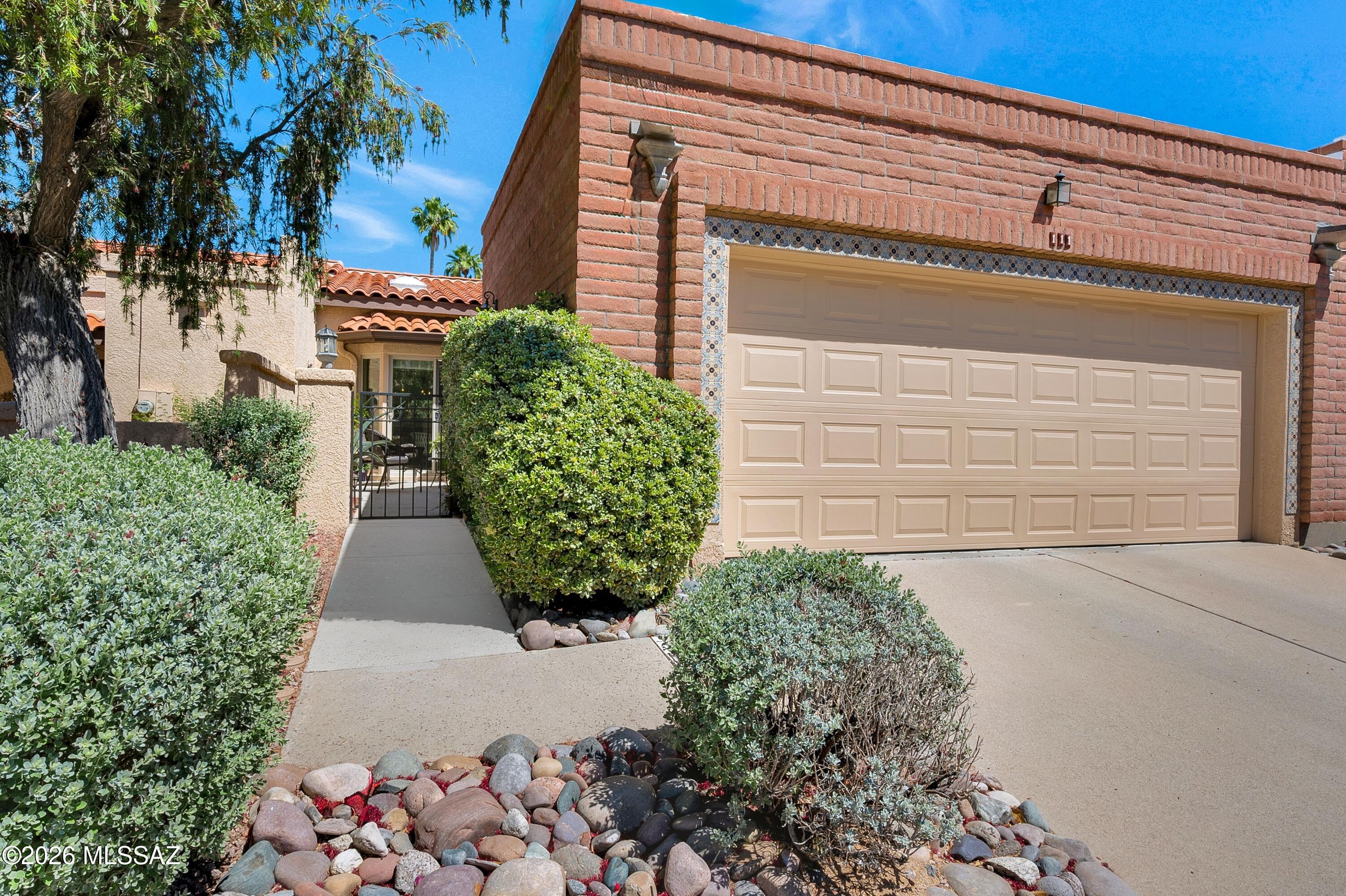 A charming private courtyard welcomes you to this spacious territorial style home with soaring vaulted ceilings, abundant light, and an ideal north facing patio with Catalina Mountain views to the east. Thoughtful updates throughout enhance this open and happy, easy-care townhouse.  Plenty of extra storage is tucked in.  Primary ensuite with huge, bright walk-in closet and remodeled bath.  Guest room/office with a murphy bed.  Bedroom and dining room set available on a separate bill of sale.  New Heat pump (2025).  Community amenities include heated pool, spa, clubhouse and walking trail.  Enjoy the very best of living in this Valle Del Oro Townhome, located minutes from Oro Valley Country Club, El Conquistador resort, numerous restaurants, shops and more.