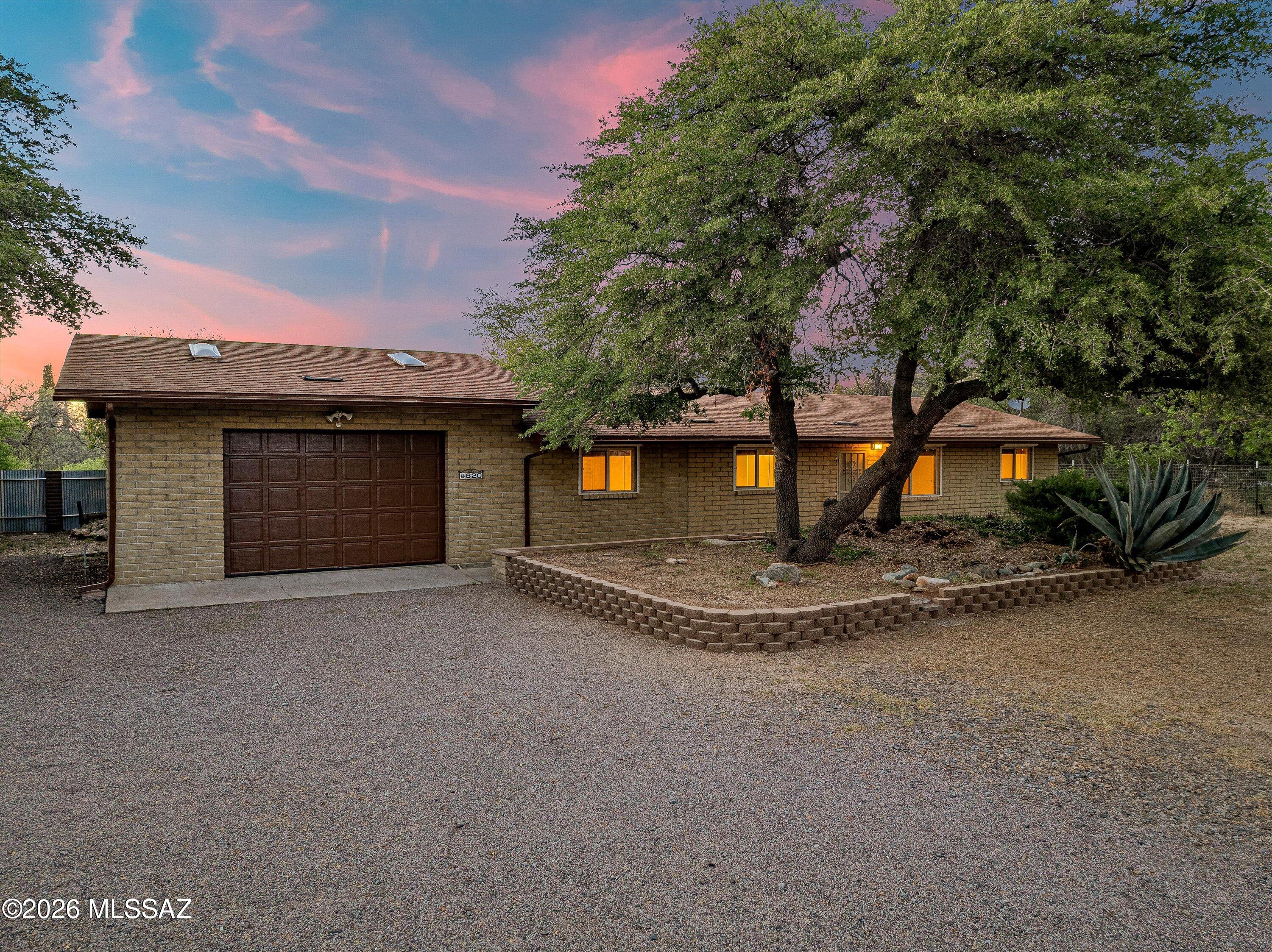 Escape the constant activity of urban existence and discover this charming residence in Oracle, AZ. This meticulously updated home features three bedrooms, two and a half bathrooms, and encompasses 1,484 square feet of comfortable living space. It is complemented by a generous two-car garage with elevated ceiling height. The interior presents a bright and inviting atmosphere, showcasing freshly applied neutral tones, ceramic tile flooring throughout, and recently updated interior and exterior paint. The residence has been thoughtfully enhanced with dual-pane windows, security shutters on all windows and doors, and ceiling fans installed for increased comfort and energy efficiency. The kitchen is fully equipped with stainless steel appliances, RV Parking and 50amp hookup next to Garage! dishwasher, as well as an in-unit washer and dryer, ensuring a truly move-in ready condition. Outdoors, one can relax beneath the oversized covered patio while enjoying the tranquil views of mature oak trees and the surrounding lush greenery. The fully fenced private lot offers substantial space for personalization and the creation of a custom outdoor environment. Additional features include a chimney and a raised platform in the dining area, which presents the potential for the installation of a wood stove (verification by the buyer is advised). Seize this opportunity to acquire a peaceful sanctuary surrounded by nature while retaining access to modern conveniences.