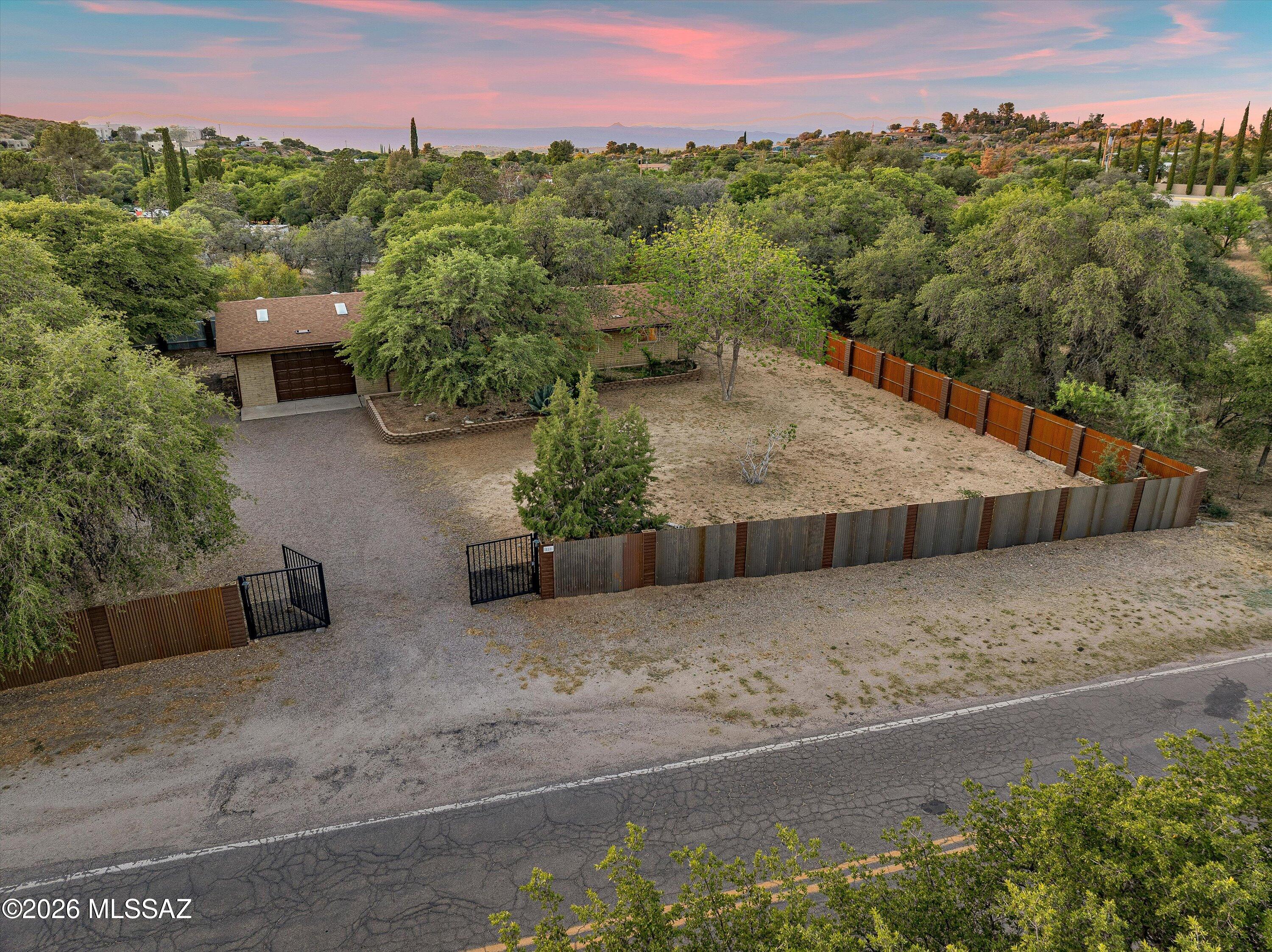 Escape the constant activity of urban existence and discover this charming residence in Oracle, AZ. This meticulously updated home features three bedrooms, two and a half bathrooms, and encompasses 1,484 square feet of comfortable living space. It is complemented by a generous two-car garage with elevated ceiling height. The interior presents a bright and inviting atmosphere, showcasing freshly applied neutral tones, ceramic tile flooring throughout, and recently updated interior and exterior paint. The residence has been thoughtfully enhanced with dual-pane windows, security shutters on all windows and doors, and ceiling fans installed for increased comfort and energy efficiency. The kitchen is fully equipped with stainless steel appliances, RV Parking and 50amp hookup next to Garage! dishwasher, as well as an in-unit washer and dryer, ensuring a truly move-in ready condition. Outdoors, one can relax beneath the oversized covered patio while enjoying the tranquil views of mature oak trees and the surrounding lush greenery. The fully fenced private lot offers substantial space for personalization and the creation of a custom outdoor environment. Additional features include a chimney and a raised platform in the dining area, which presents the potential for the installation of a wood stove (verification by the buyer is advised). Seize this opportunity to acquire a peaceful sanctuary surrounded by nature while retaining access to modern conveniences.