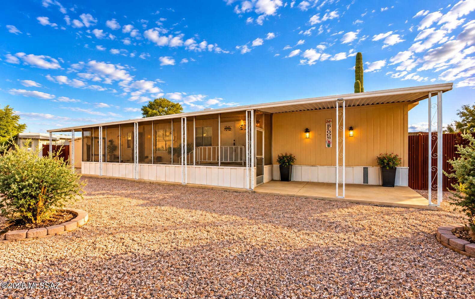 Welcome to this charming 3-bedroom, 2-bath home on a spacious corner lot in the desirable Orange Grove Mobile Estates of Northwest Tucson! Featuring a split-bedroom floor plan and inviting open-concept living area, this home offers comfort and functionality. The kitchen boasts abundant cabinetry and generous counter space. Relax on the spacious screened-in front porch or enjoy the privacy of the fully fenced backyard. Additional features include an extended covered carport and storage shed. Community amenities include a pool, spa, basketball court, playground, and clubhouse. Conveniently located near I-10, Northwest Medical Center, shopping, dining, and just minutes from Sprouts Farmers Market and Costco!