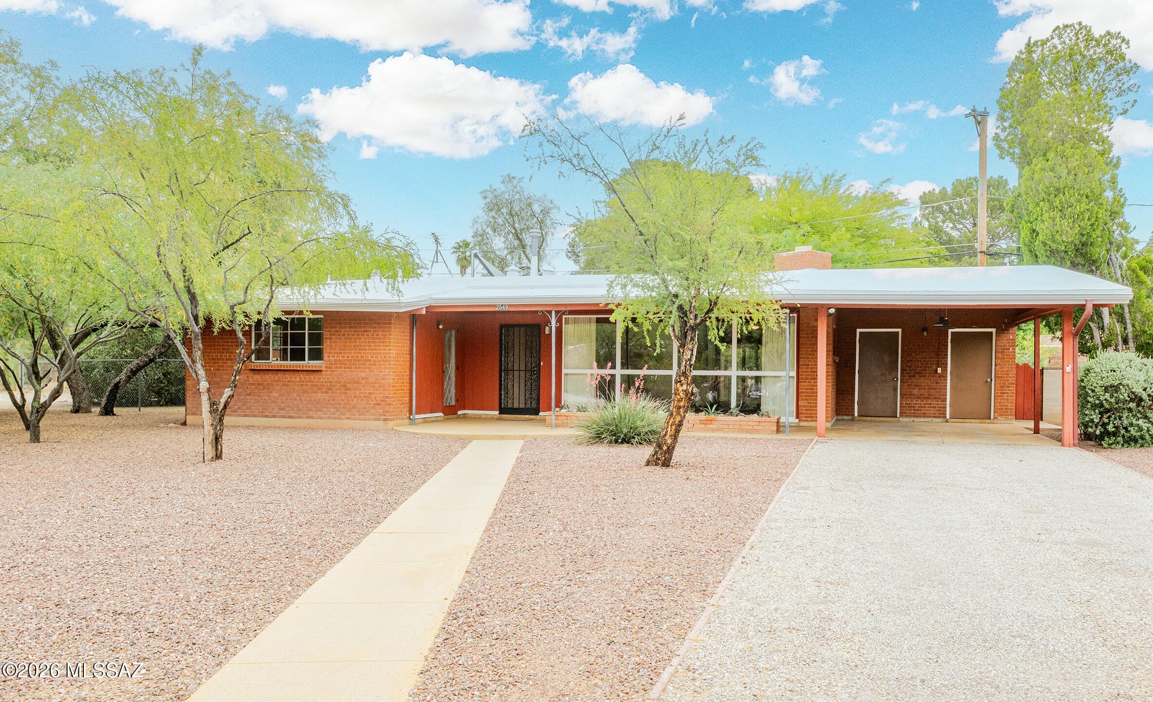 Classic Mid-Century Modern architecture charm meets a prime north central Tucson location in this 1954 red brick beauty. Signature angles and cathedral ceilings, this home captures the era while offering comfortable everyday living. Living room features red=brick fireplace and a wall of windows that floods the space with natural light.  Primary suite has its own entrance, walk-in closet and just-remodeled primary bathroom!  Screened patio room is awesome, as is the dedicated desert garden planter by entrance.
Set on a spacious lot at the end of a quiet cul-de-sac, plenty of room to relax, entertain, or expand. Ideally located near the Loop, popular Campbell Avenue restaurants, and U of A is close at hand.  Rare opportunity to own an architectural showpiece in a sought-after neighborhood!