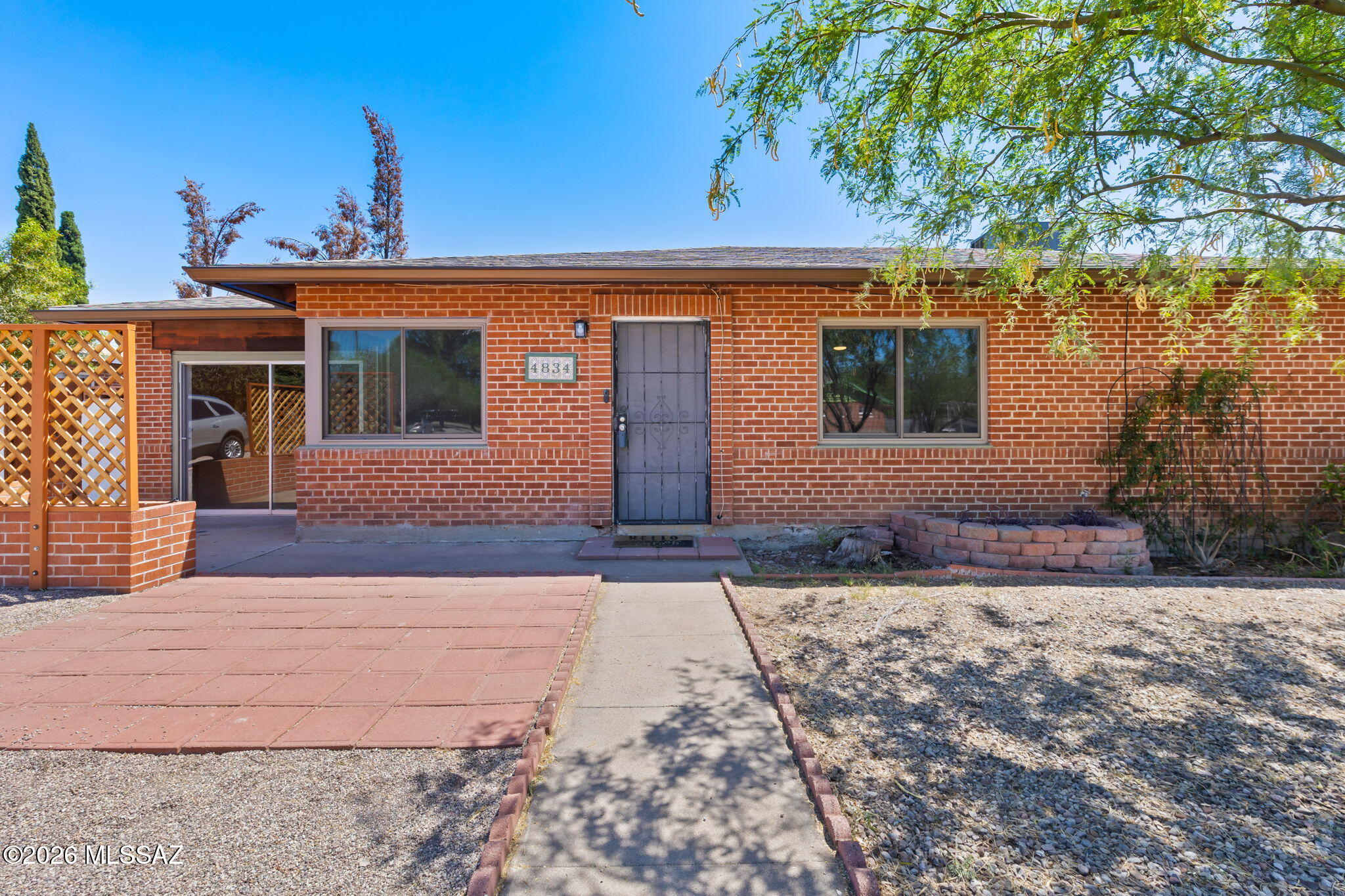 Located in central Tucson, in a quaint neighborhood close to a park, this charming three bedroom and two bath home sits on almost a quarter acre lot! With modern day updates, while maintaining the charm of the 1950's, this home offers a bright open floorplan with an abundance of space. The stylish kitchen serves as the heart of the home, showcasing stunning Brazilian granite countertops, rich dark wood cabinetry, and a spacious butcher block island perfect for meal preparation, entertaining, or casual dining. The main living areas feature attractive ceramic wood-look tile flooring that combines the warmth of hardwood with the durability and ease of tile. In the bedrooms, custom colored concrete floors add a unique contemporary touch while offering low-maintenance practicality and cooler summer months. The versatile bonus room can serve as a fourth bedroom, as a closet has already been added, or a separate family room. Step outside to enjoy the fenced backyard porch, creating a private outdoor retreat perfect for relaxing, entertaining guests, or enjoying Tucson's beautiful year-round weather. The oversized yard is your blank slate to bring your dreams to reality. For the handy hobbyist, enjoy a bonus workshop off the laundry room for all your yard tools or hobby storage.