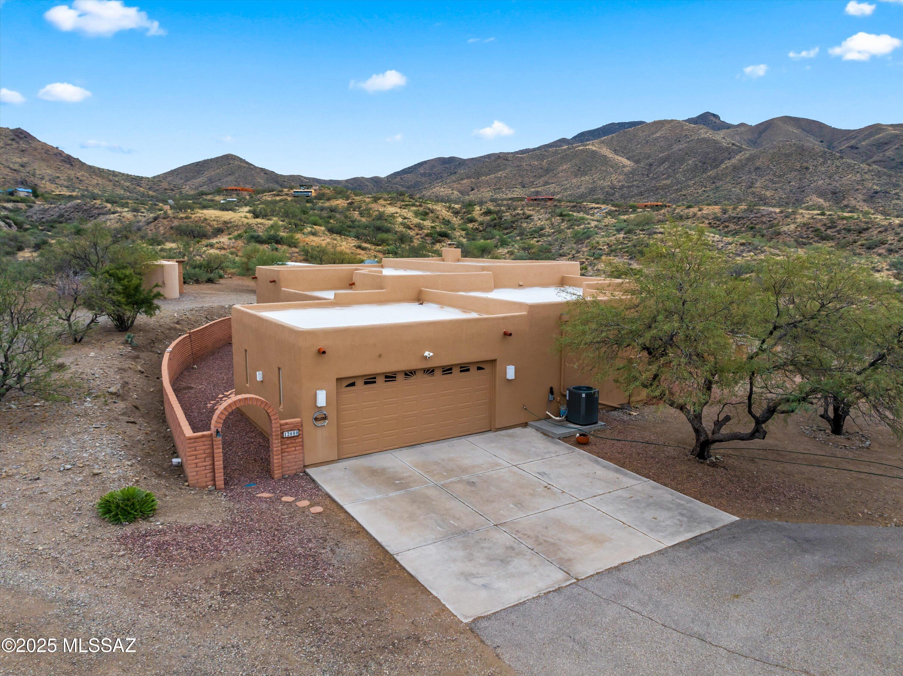 Custom home built in 2000 on 4.98 acres of horse property in Vail, offering peaceful country living with sweeping 360-degree views. Nestled near the Santa Rita Mountains, this property features a welcoming front courtyard & screened Az Room ideal for enjoying the desert year-round. Great room showcases soaring 14-foot ceilings & a wood burning Bee Hive fireplace. Kitchen is open to living space & formal dining room nearby.  Lge bedrooms & bathrooms provide comfortable living. Plenty of storage, huge pantry & walk in closets. Flooring includes tile & engineered wood throughout. Notable updates include a new heat pump, stove and microwave in 2023, along with a whole-house Halo water purification system. Low care plants include citrus & rosemary. Wildlife sightings add to the serene setting.